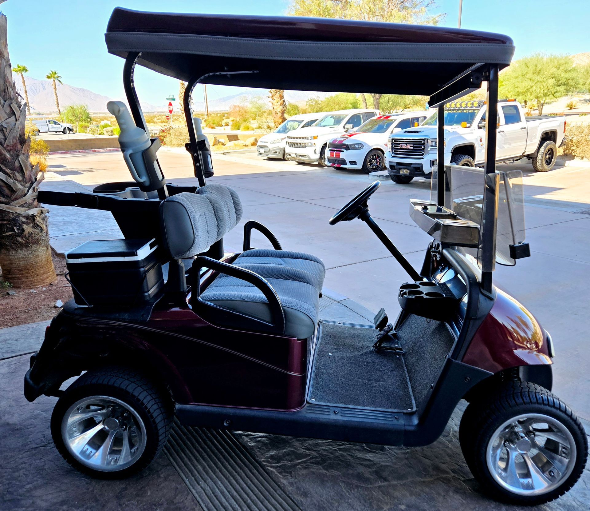 A red golf cart is parked in a parking lot