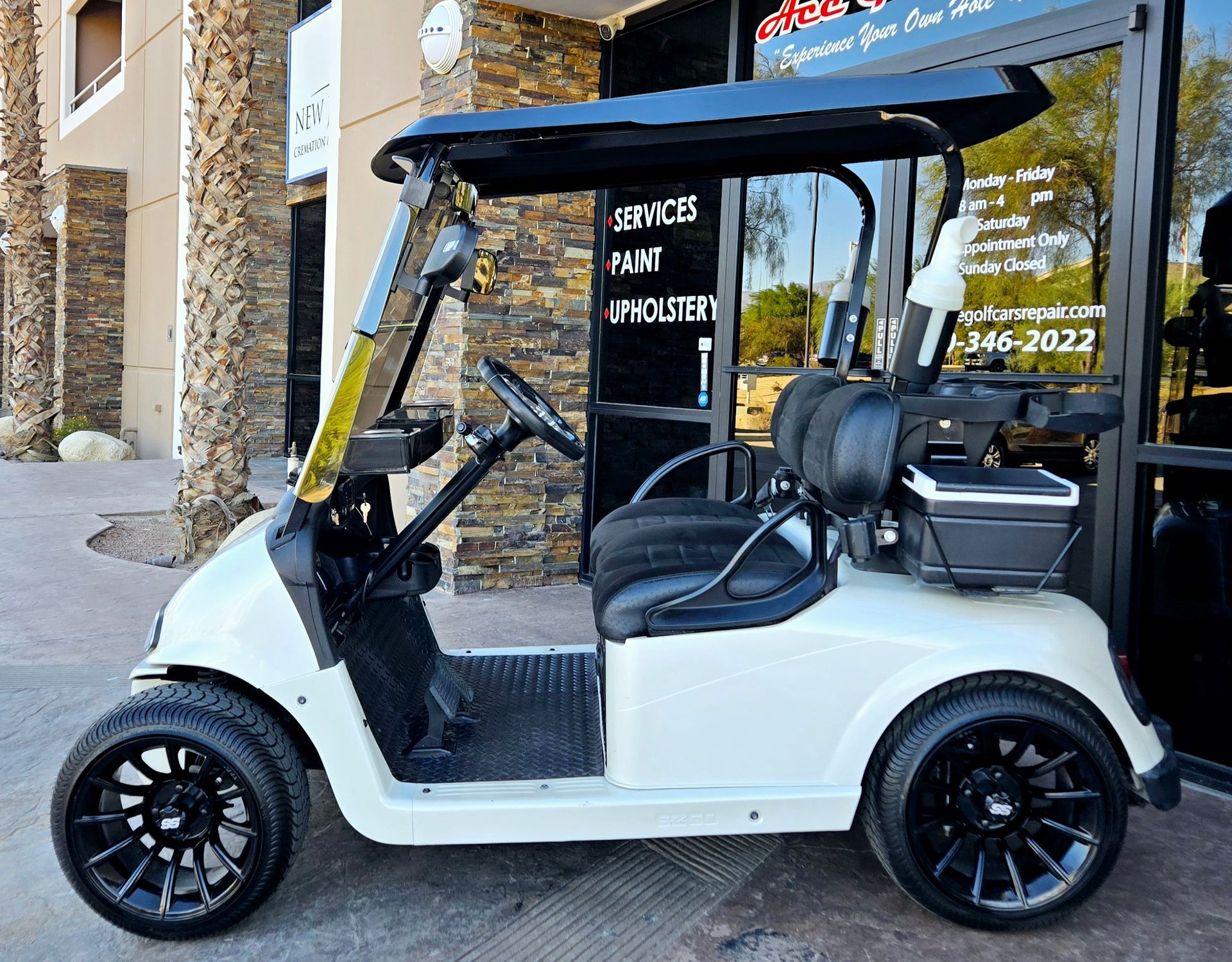 A white golf cart is parked in front of a building