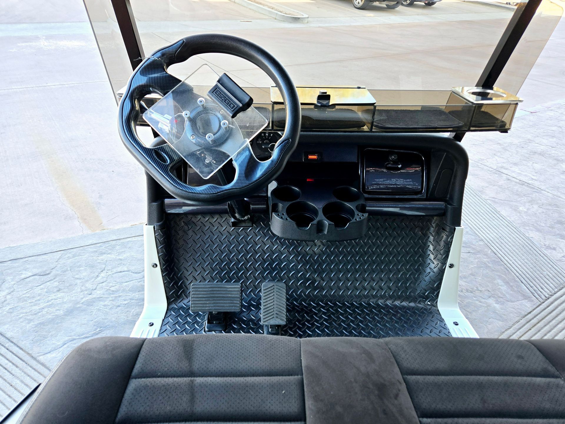 The inside of a golf cart with a steering wheel