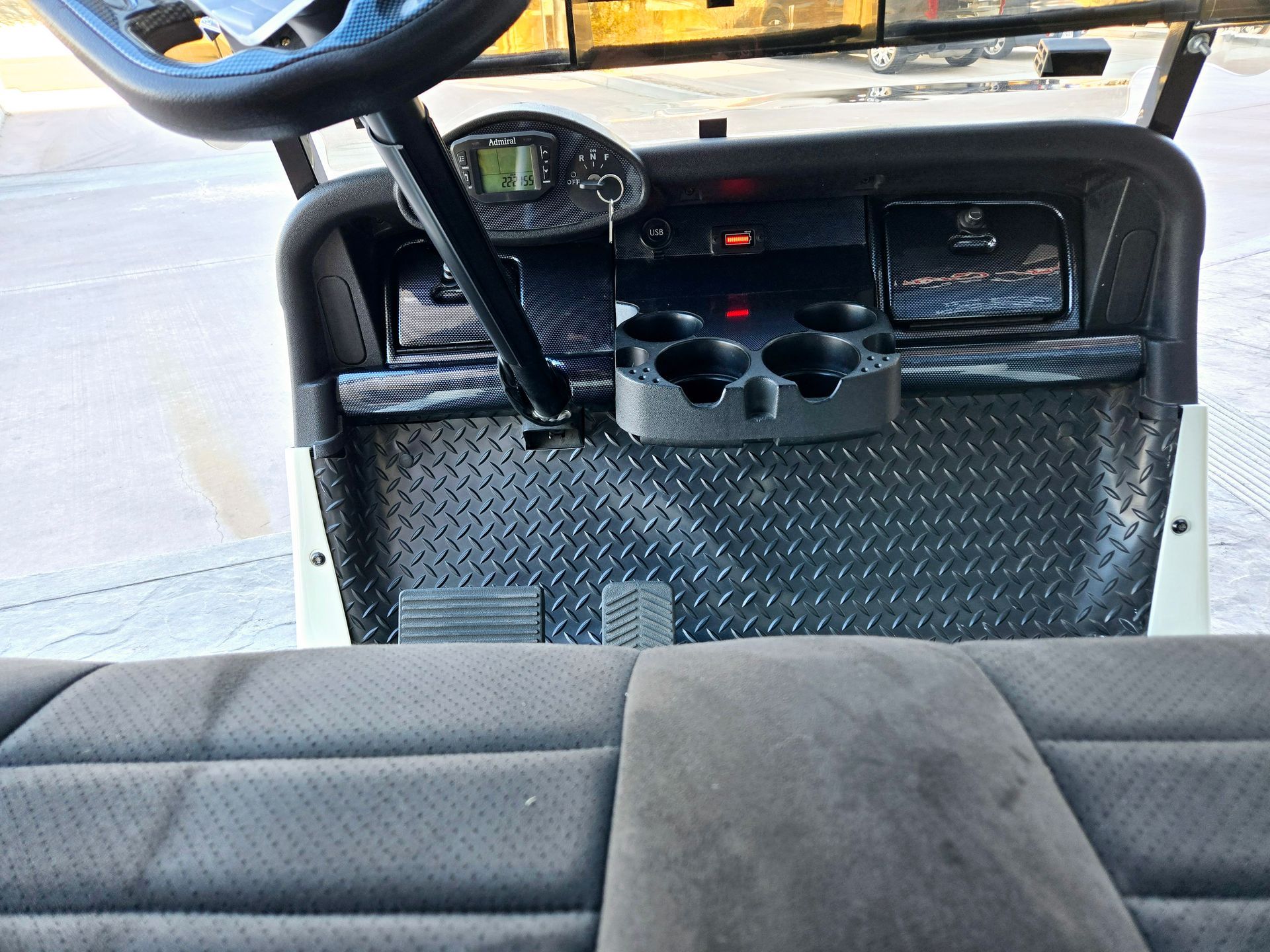 The inside of a golf cart with a steering wheel