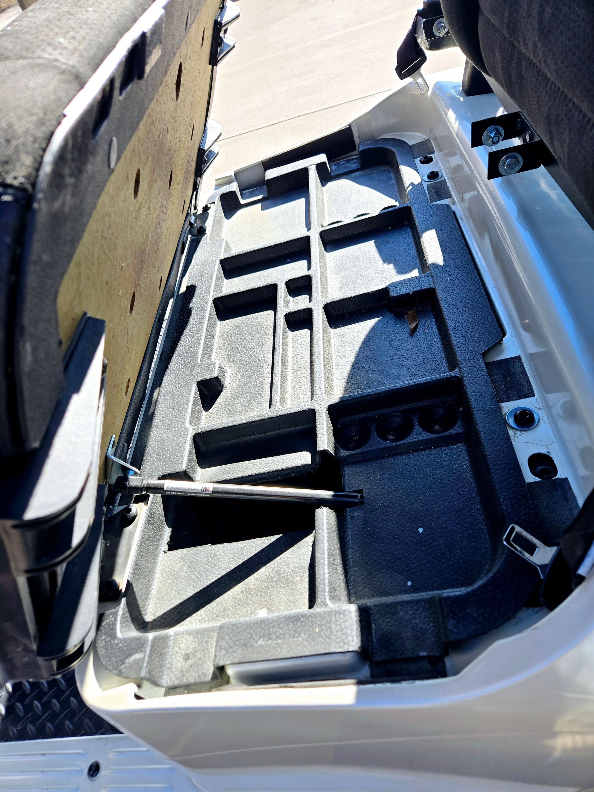 The trunk of a car is open and has a toolbox in it.