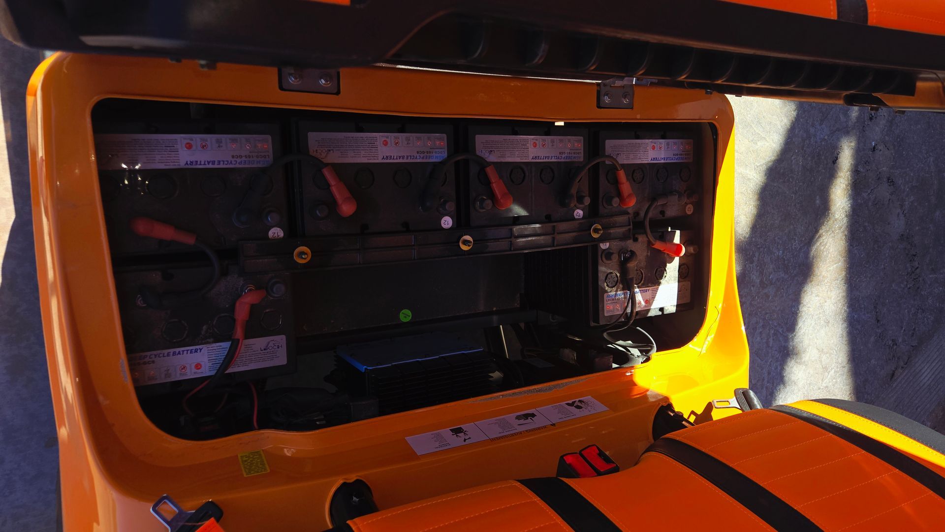 The back of a yellow and black vehicle with the hood open.