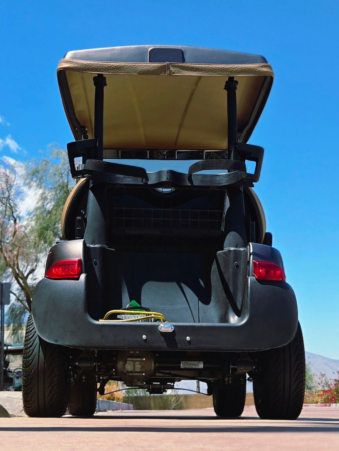 The back of a golf cart with the trunk open