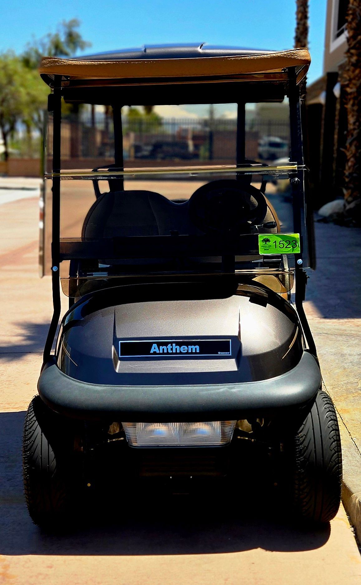 A black golf cart is parked on the side of the road