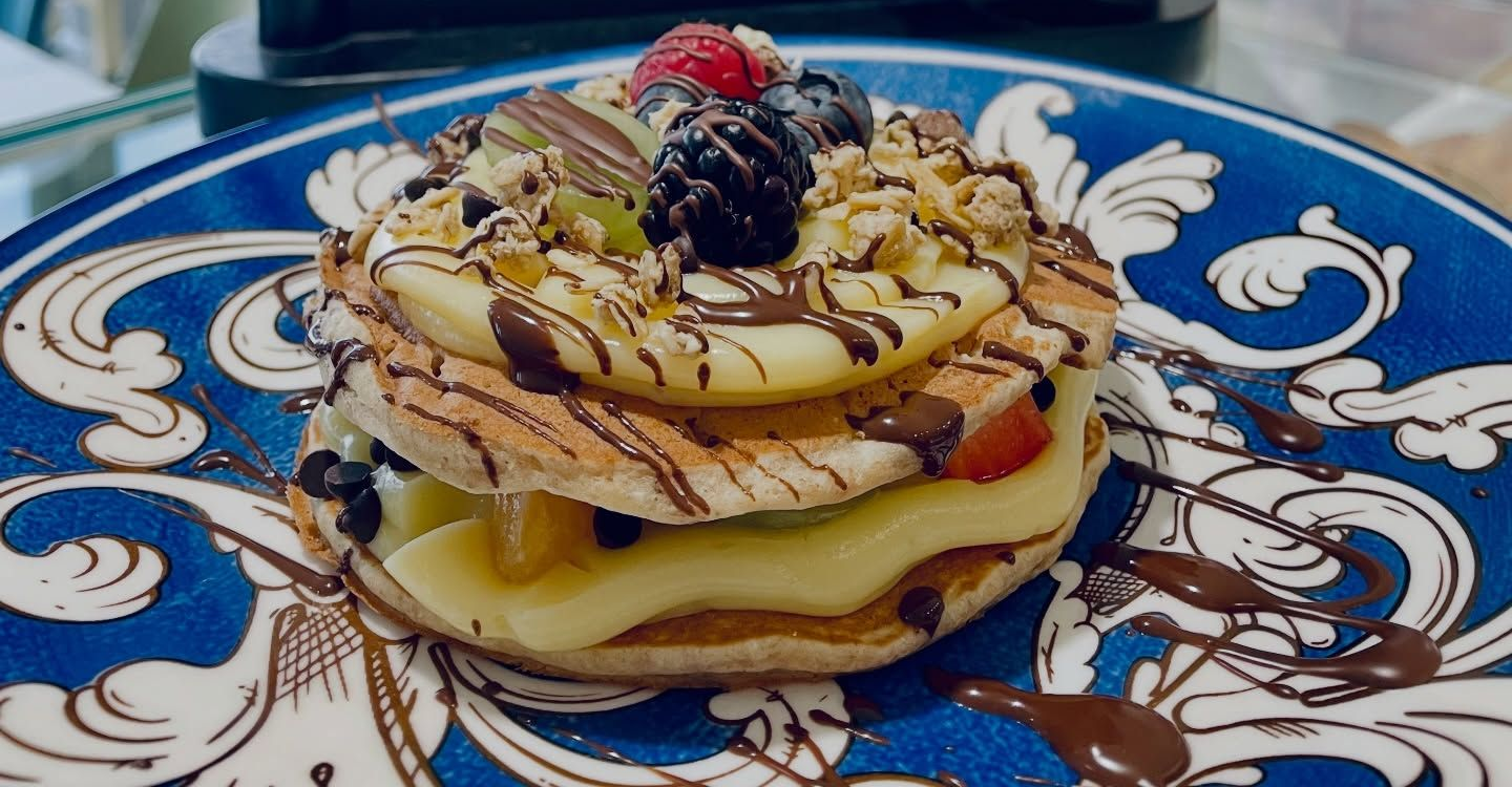 Vetrina con pasticcini assortiti e vorticosi nei colori arancione, marrone e verde.