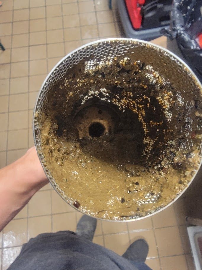 A person is holding a dirty metal object in their hand