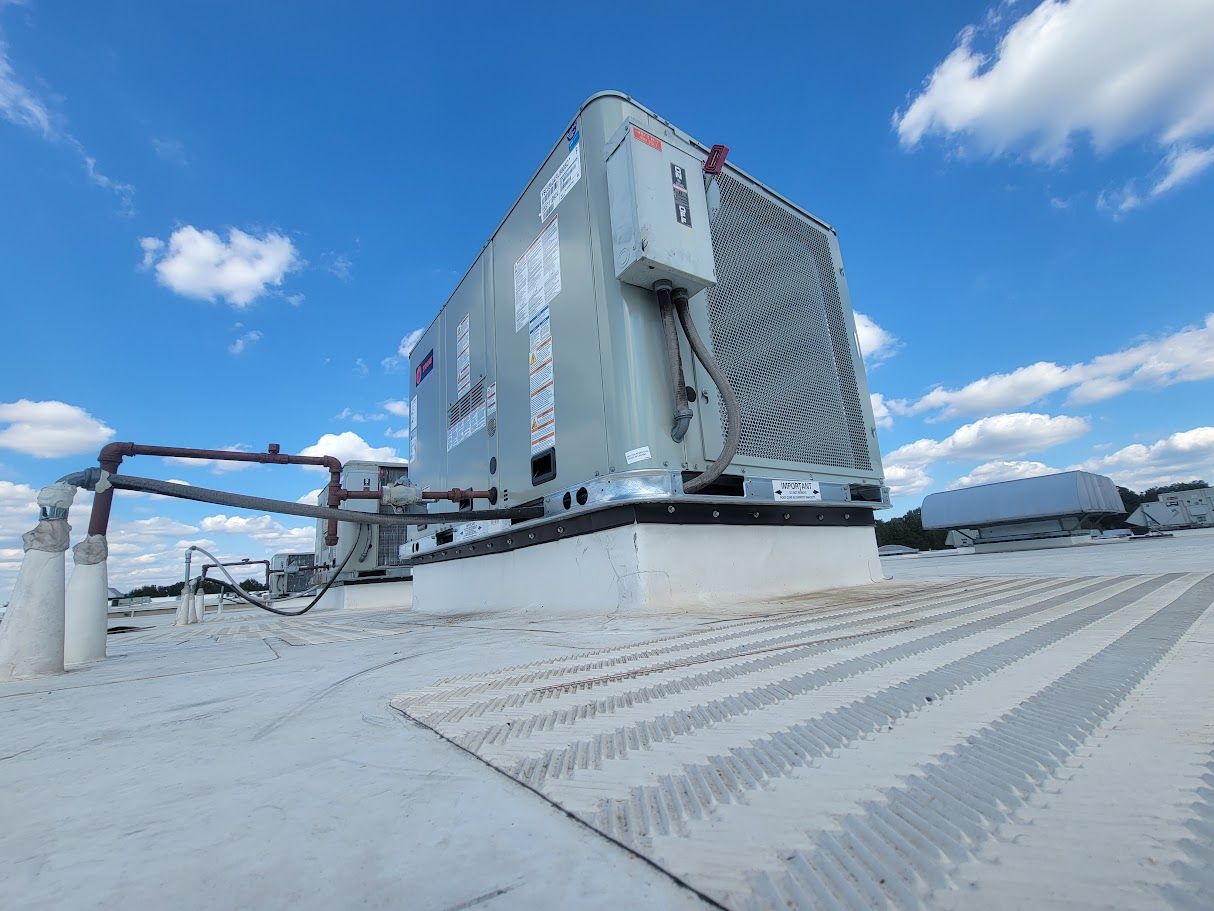 A large air conditioner is sitting on top of a roof.