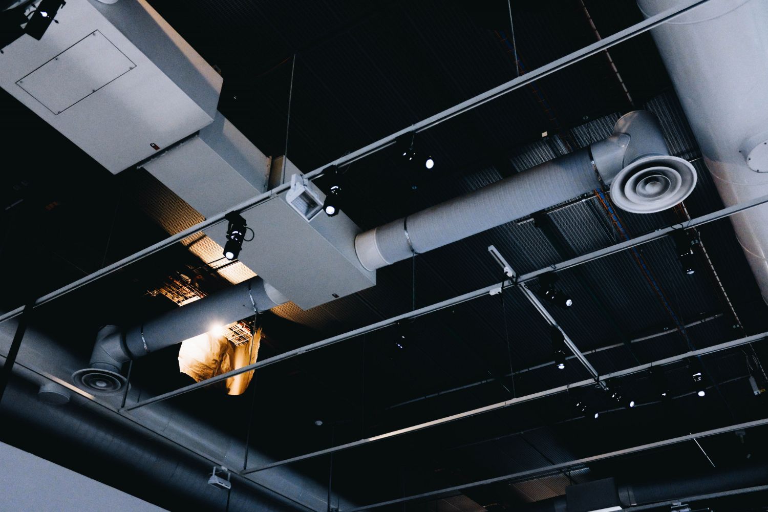 A ceiling with a lot of pipes hanging from it