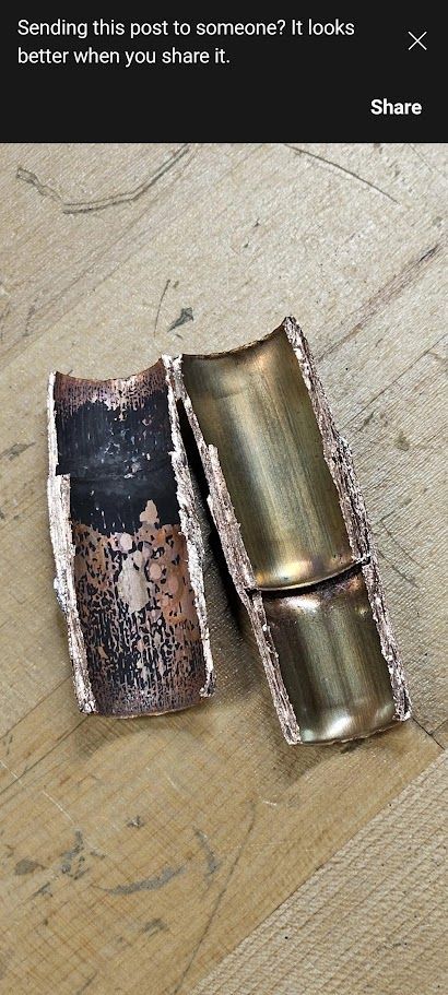 Two pieces of metal are sitting on a wooden table.