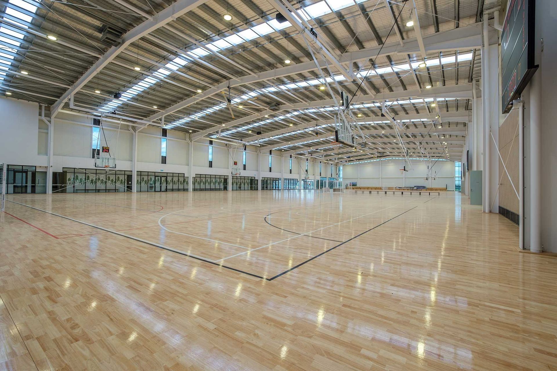 A large indoor basketball court with a wooden floor.