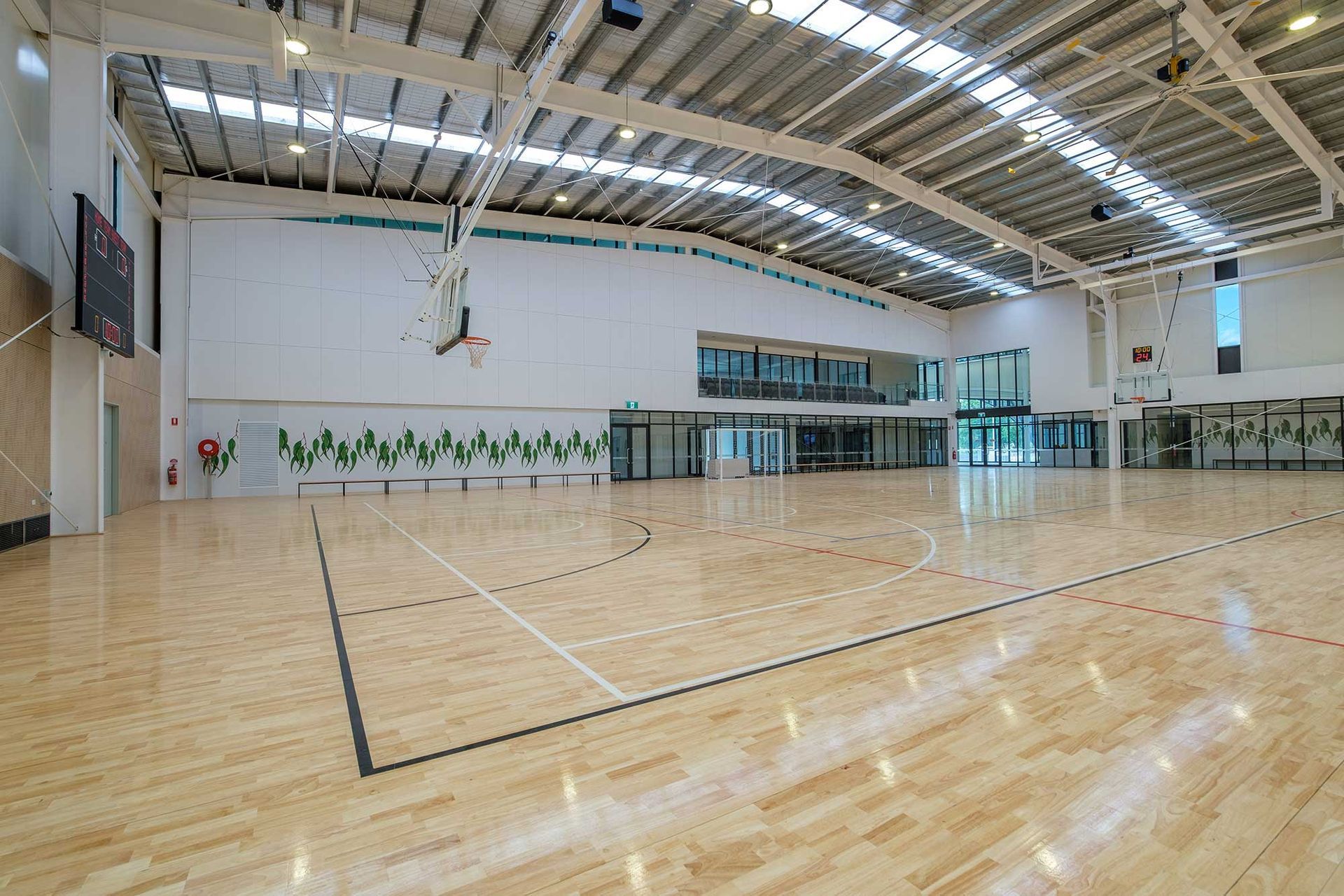 A large indoor basketball court with a wooden floor and a basketball hoop.