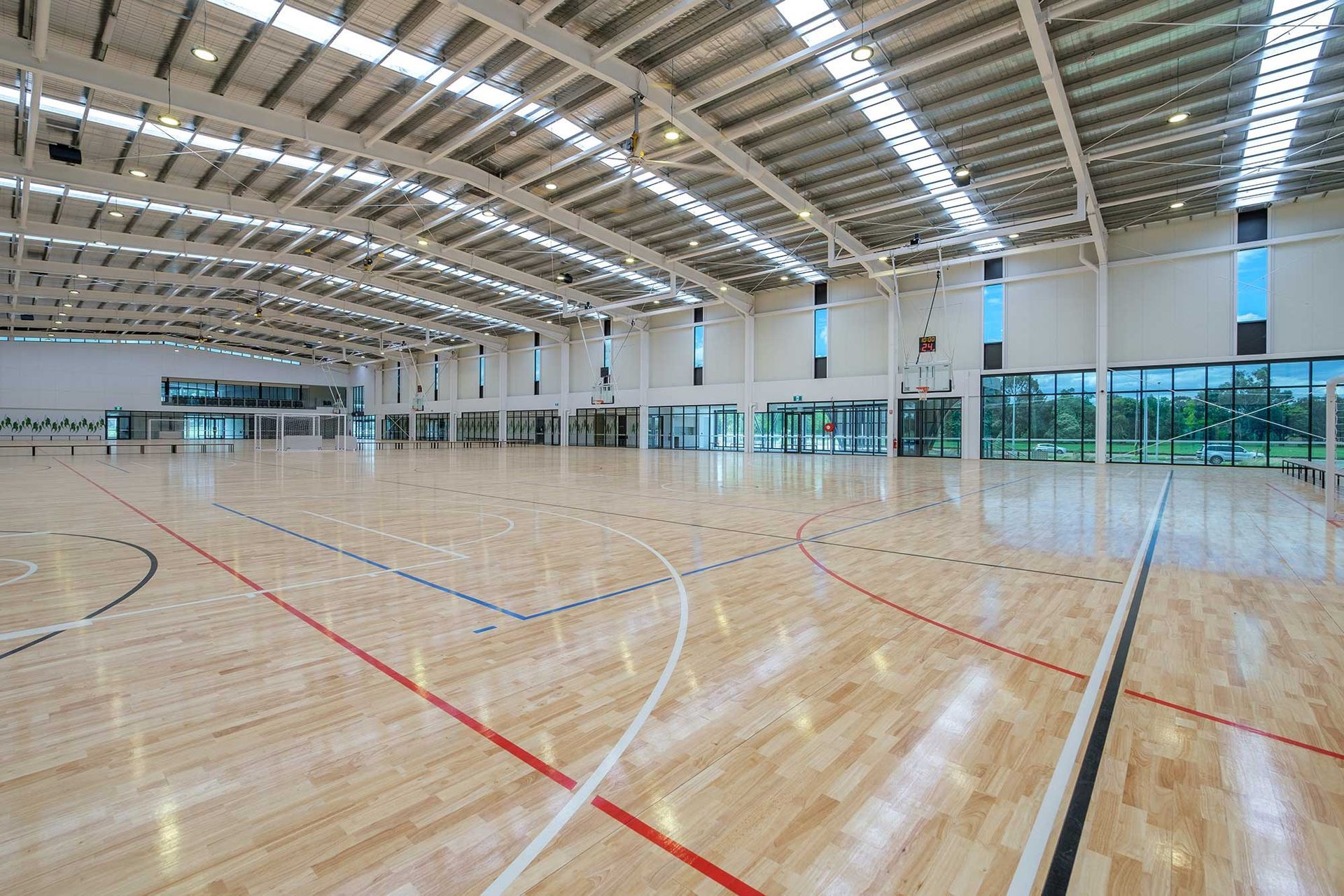 A large indoor basketball court with a wooden floor.