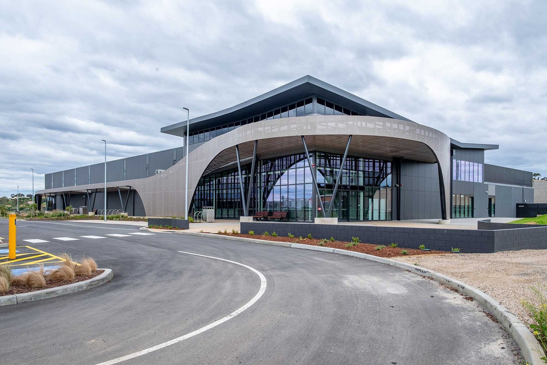 A large building with a lot of windows and a curved road in front of it.