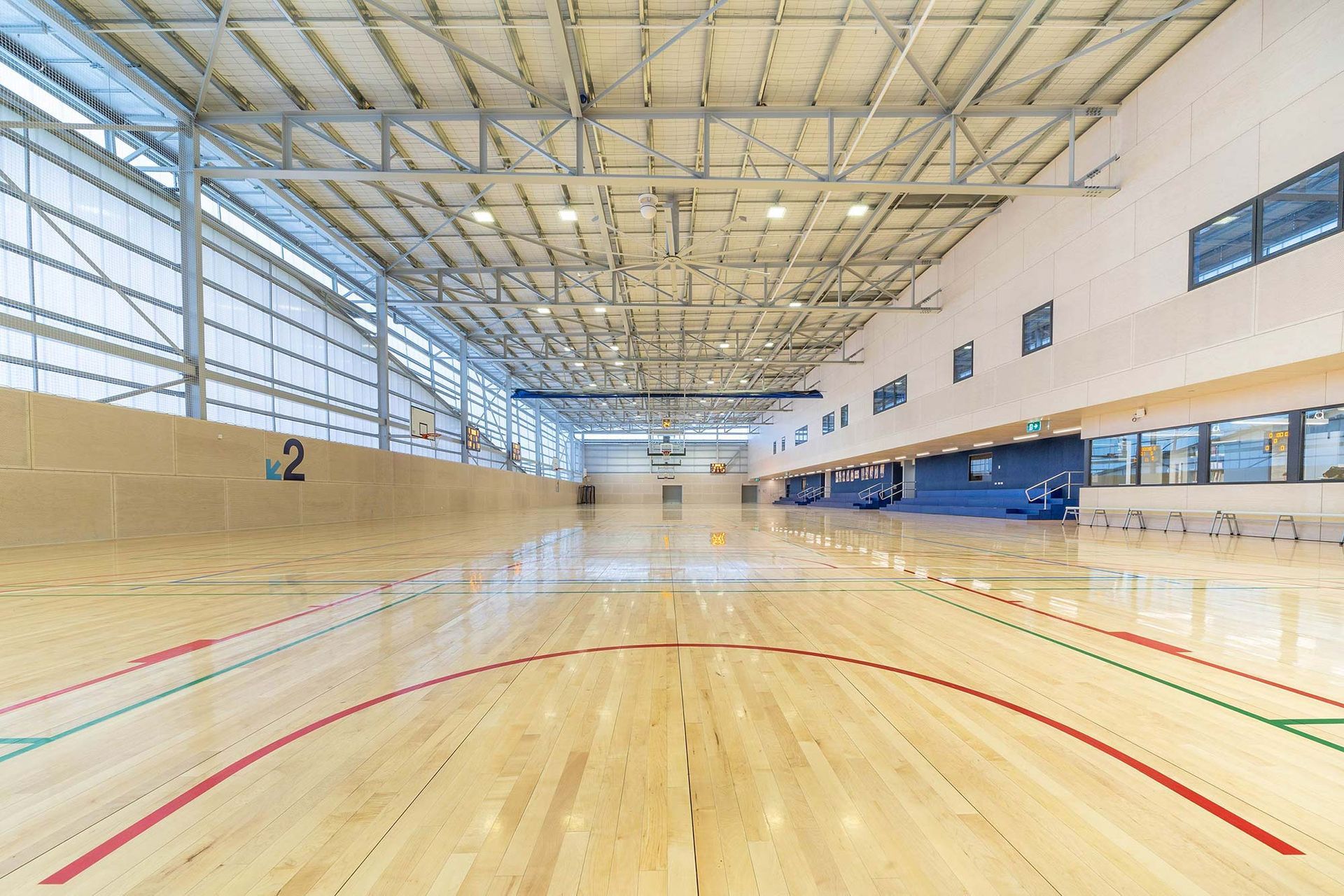 A large indoor basketball court with a wooden floor.
