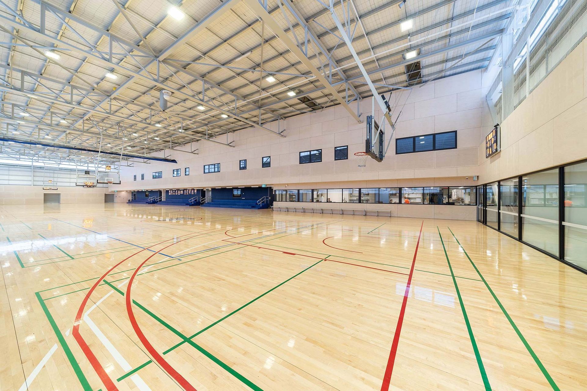 A large indoor basketball court with a wooden floor and a basketball hoop.