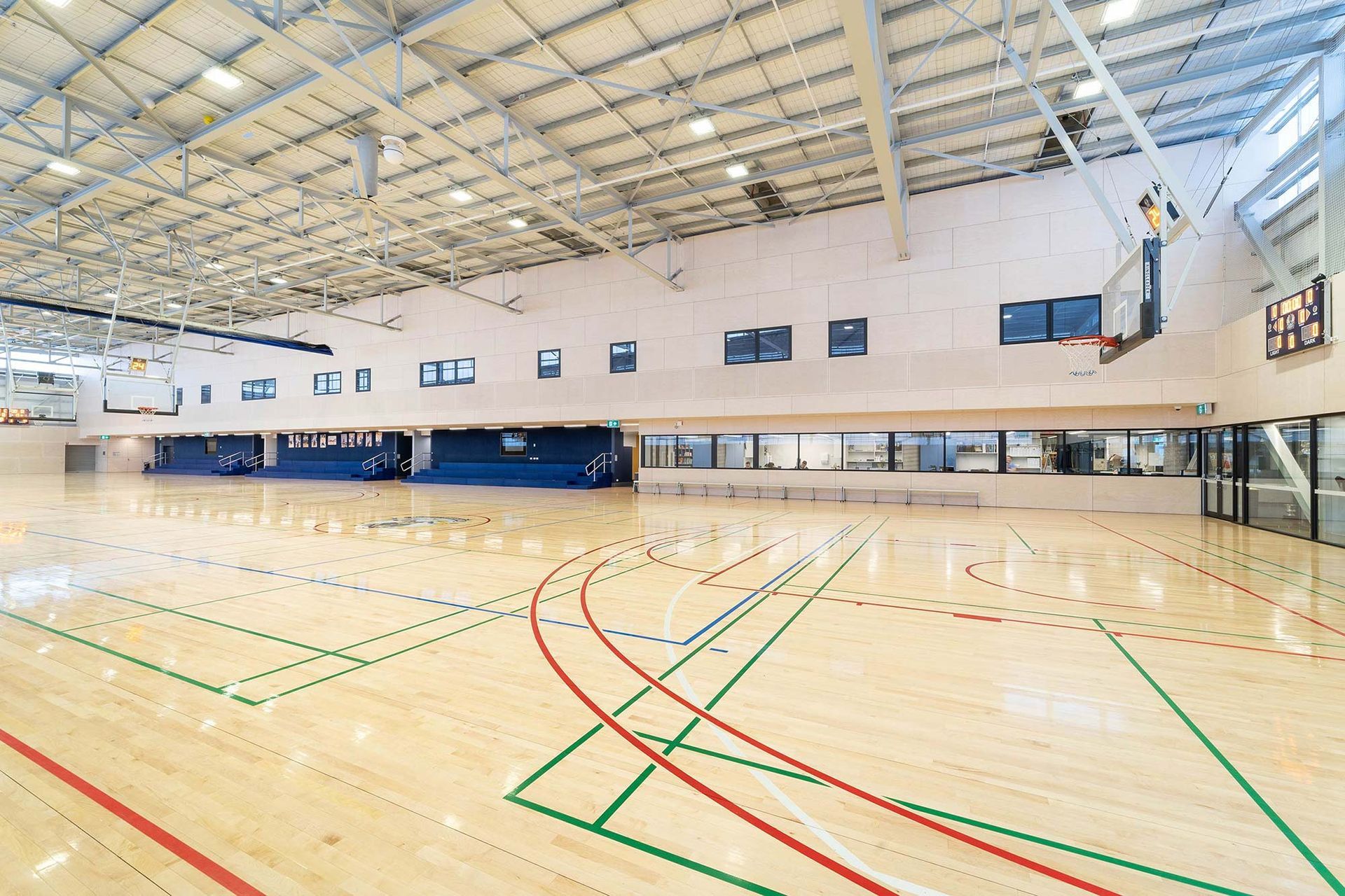 A large indoor basketball court with wooden floors and a basketball hoop.