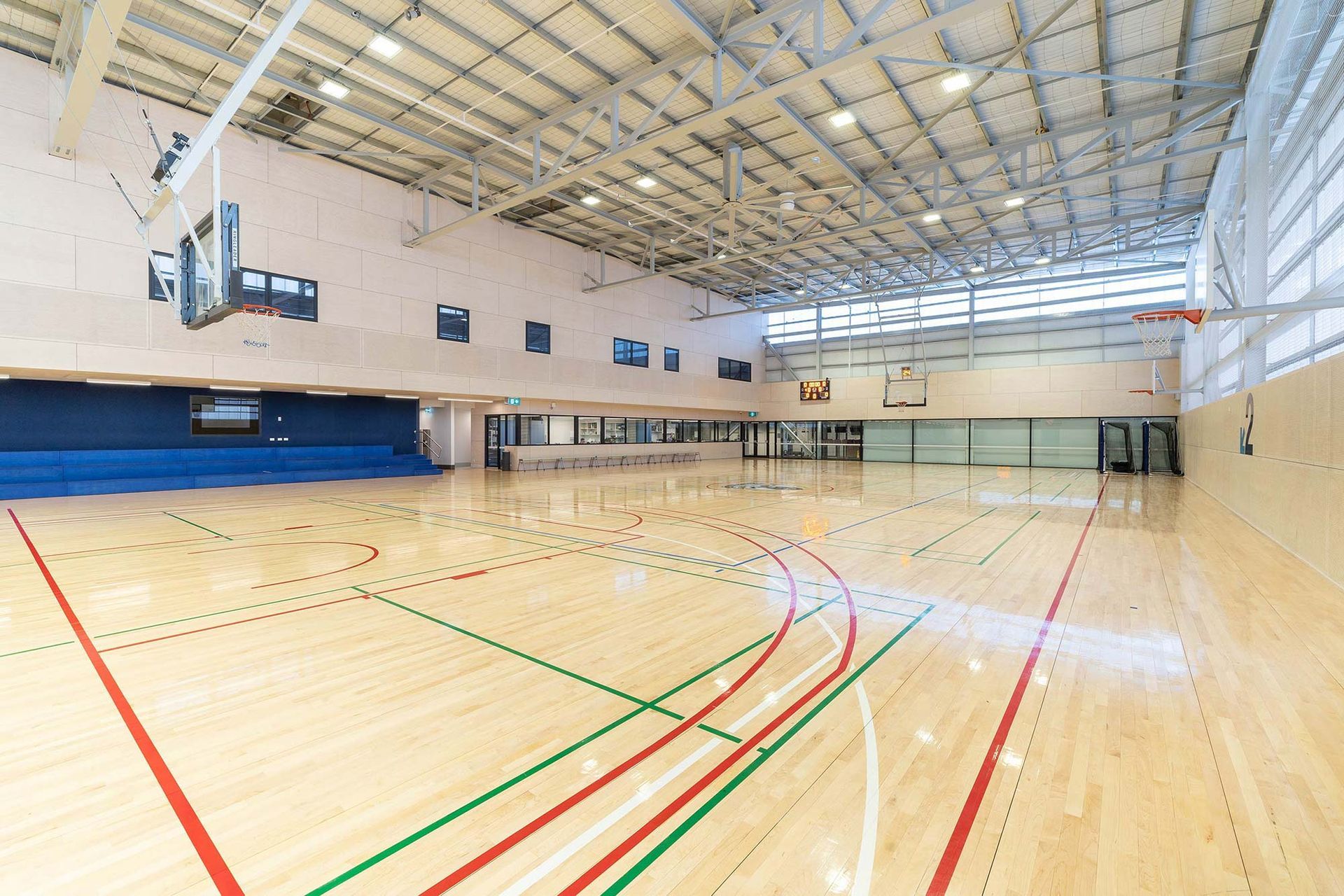 A large indoor basketball court with a wooden floor and a basketball hoop.