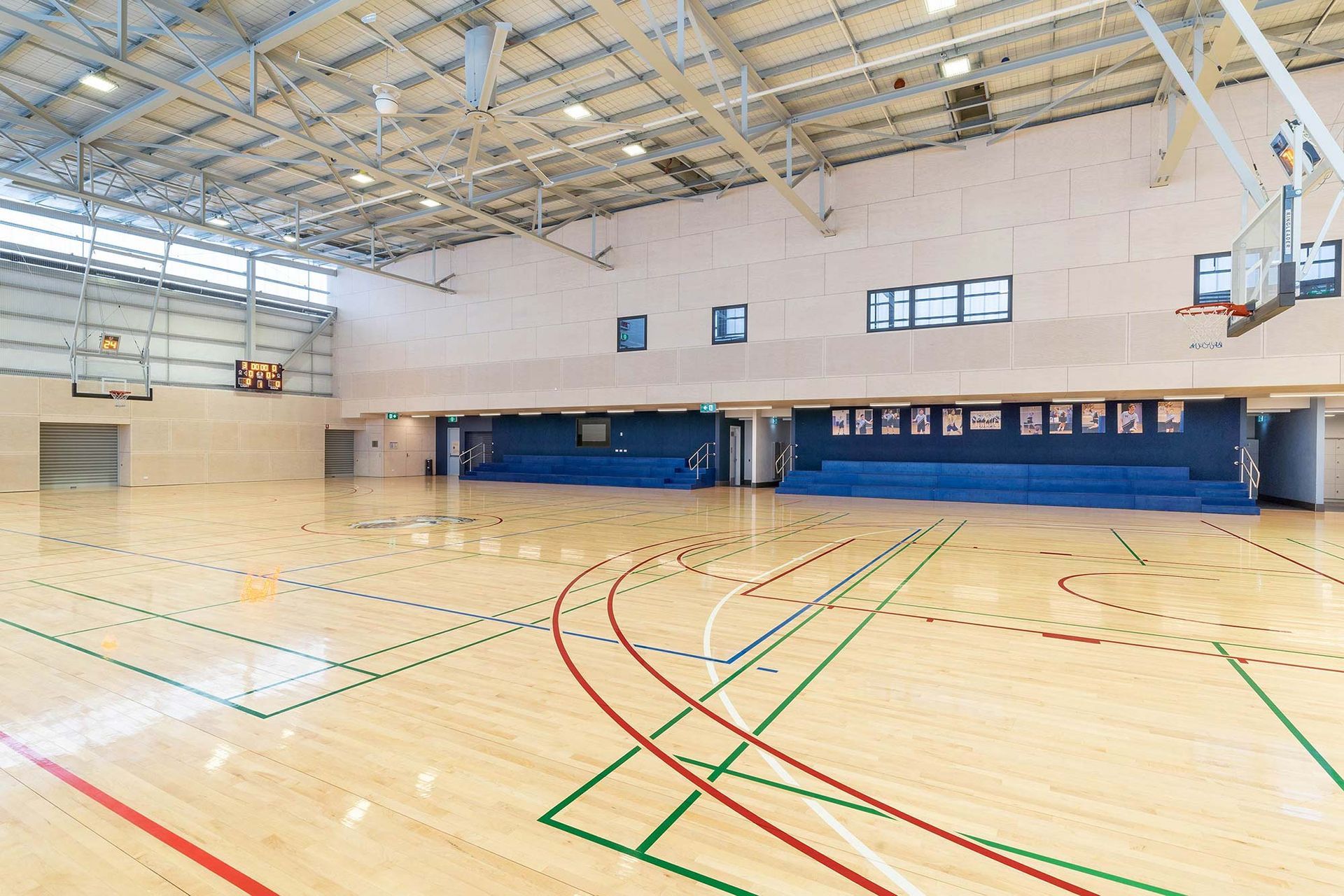 A large indoor basketball court with a wooden floor and a basketball hoop.