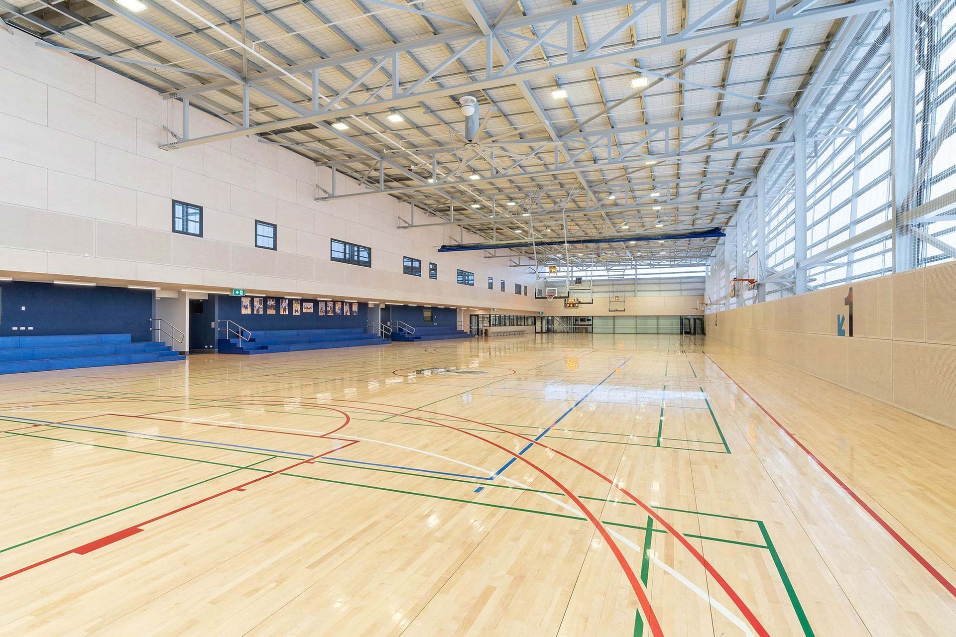 A large indoor basketball court with a wooden floor.