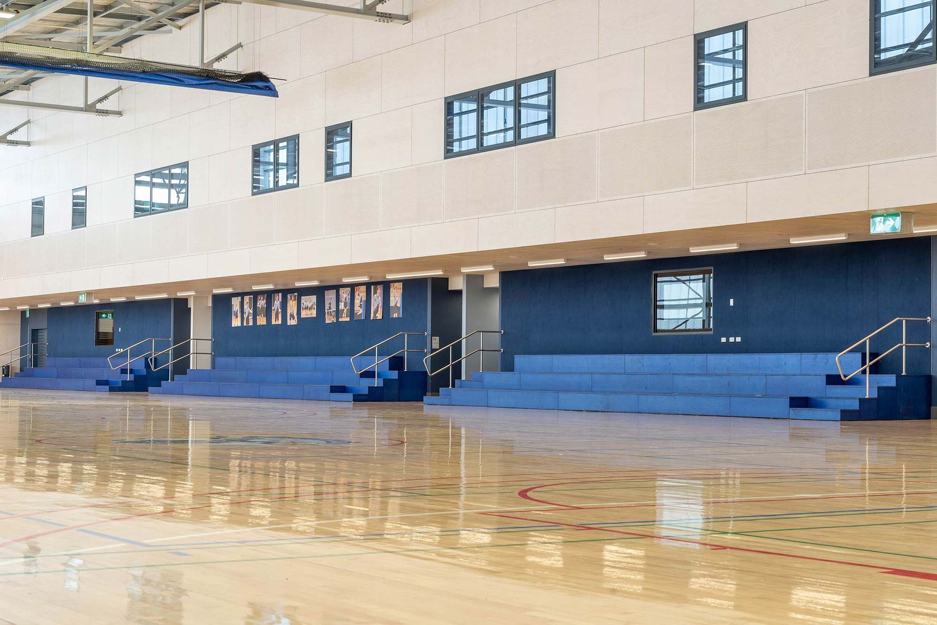 An empty gym with bleachers and a basketball court
