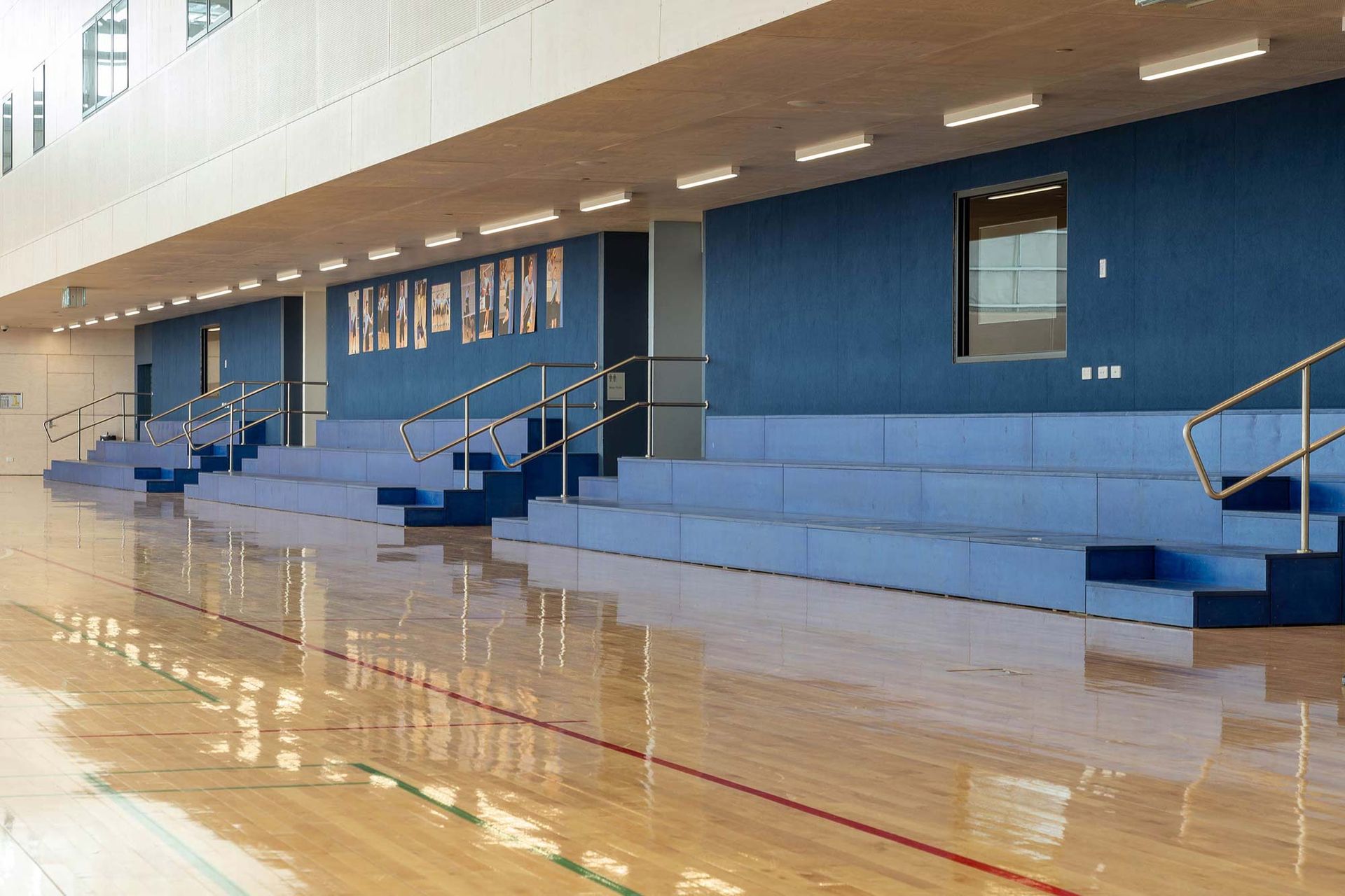 A large empty gym with bleachers and stairs