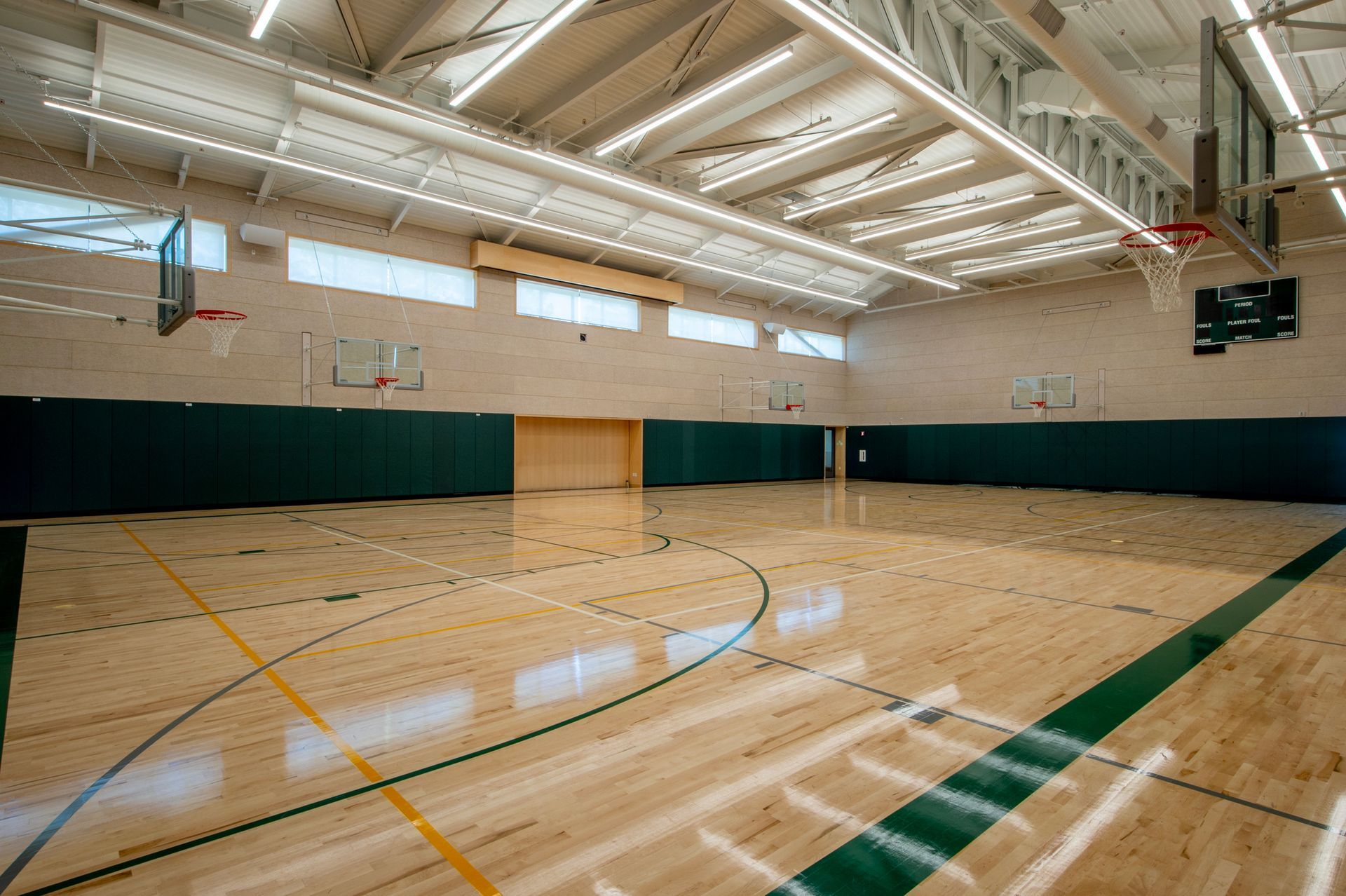 Empty school gymnasium after completion of commercial flooring services. Empty school gymnasium after completion of commercial flooring services.