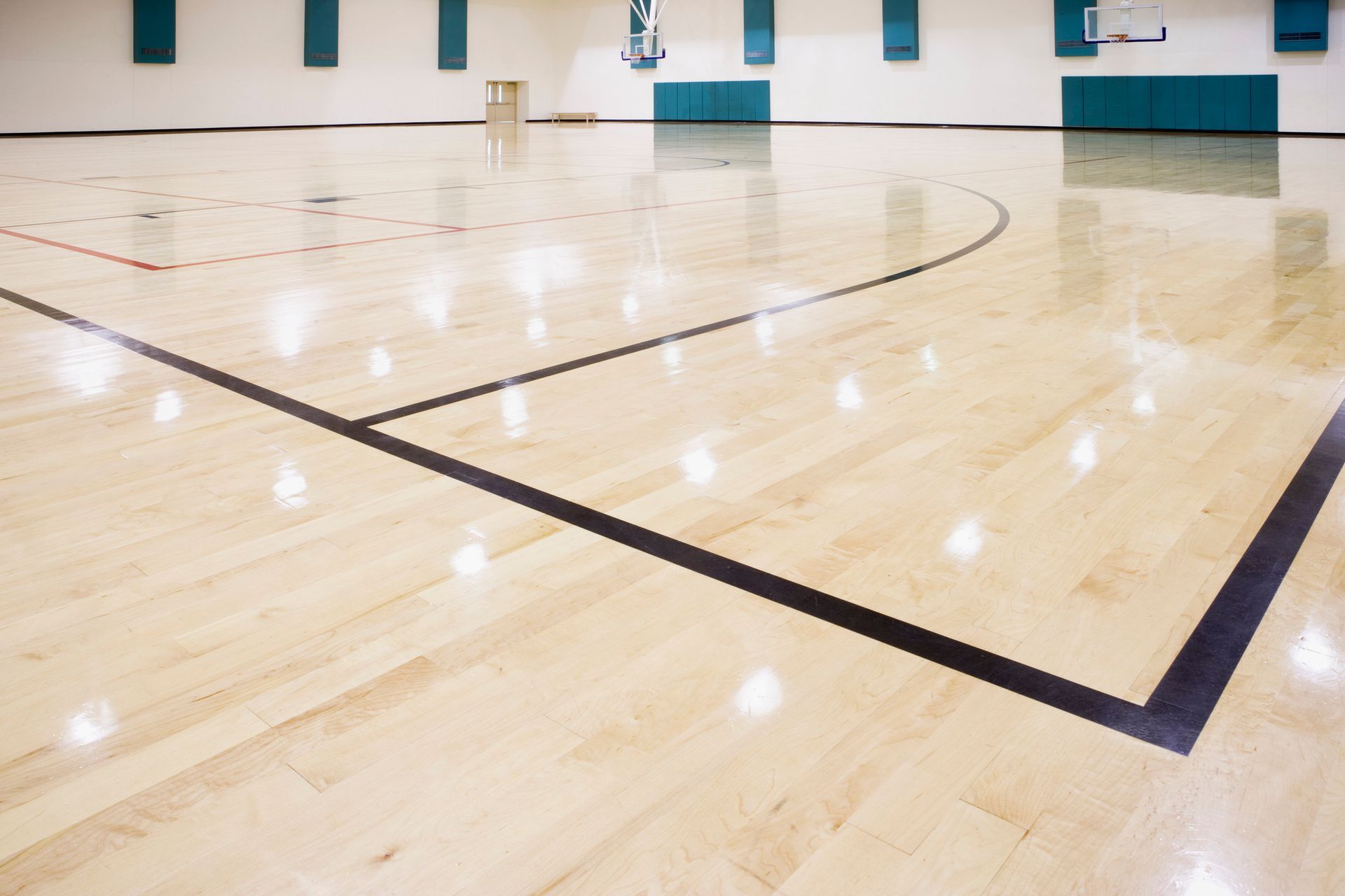 Indoor basketball court in need of domestic flooring services.