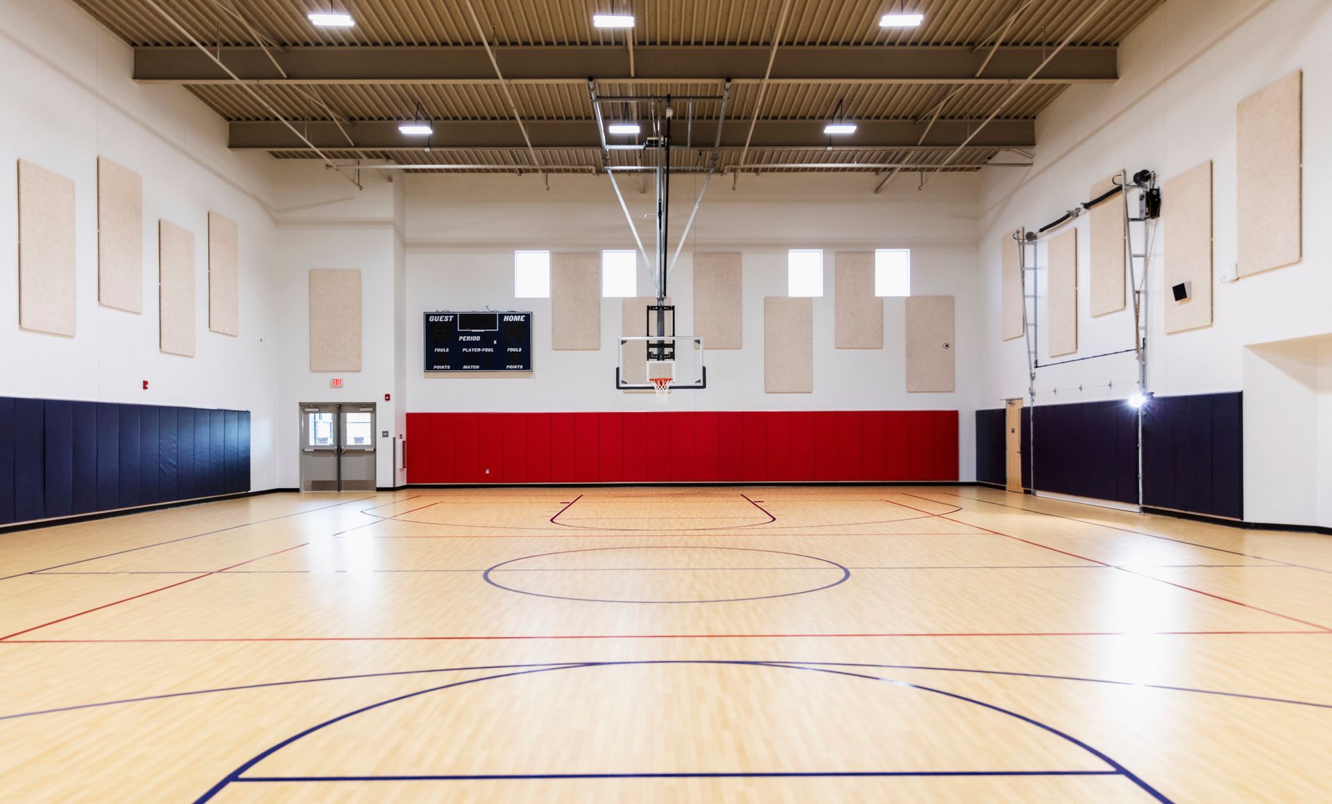 An empty school gymnasium with a basketball court. An empty school gymnasium with a basketball court.