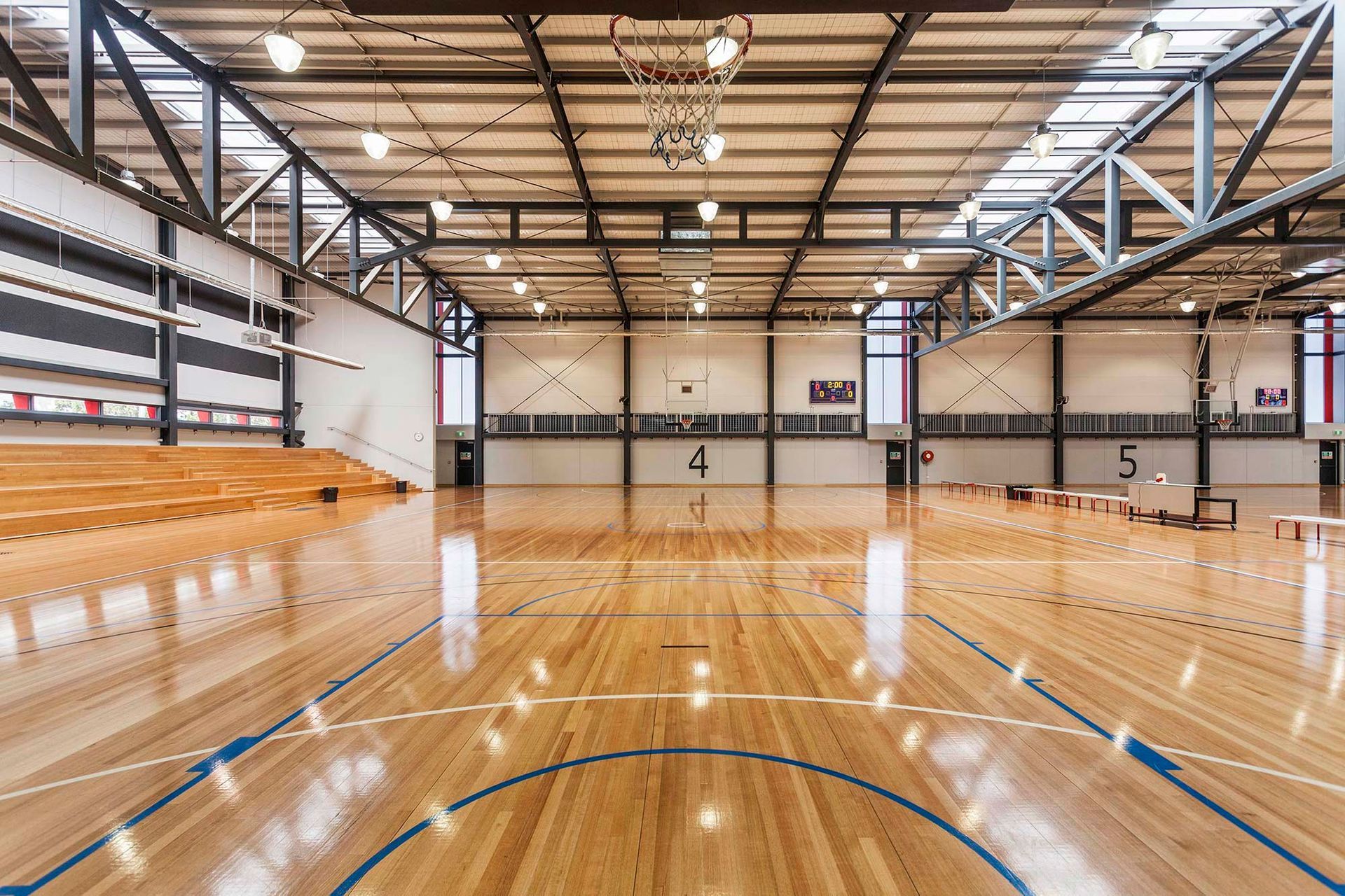 A large indoor basketball court with a wooden floor