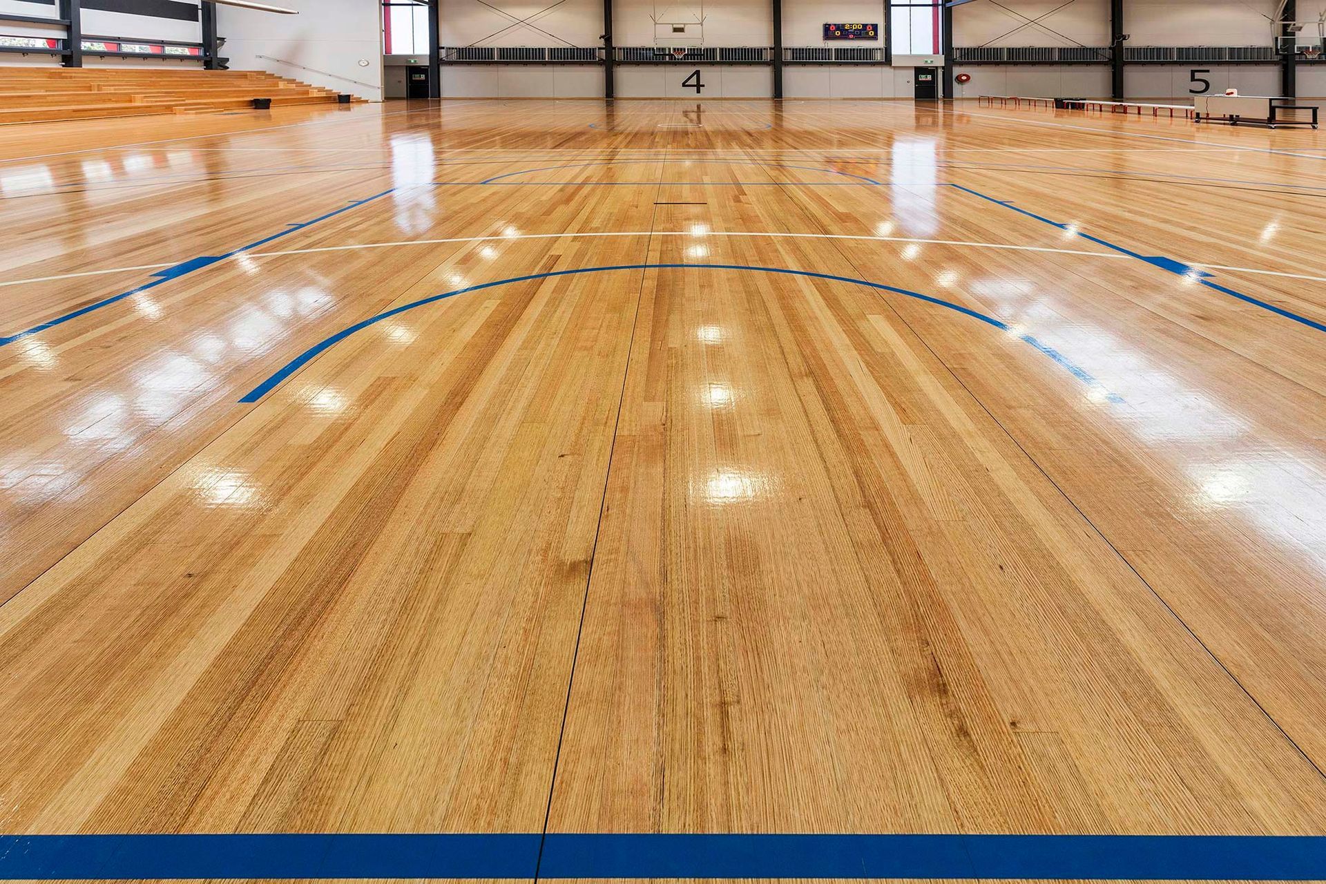 A basketball court with a wooden floor and blue lines