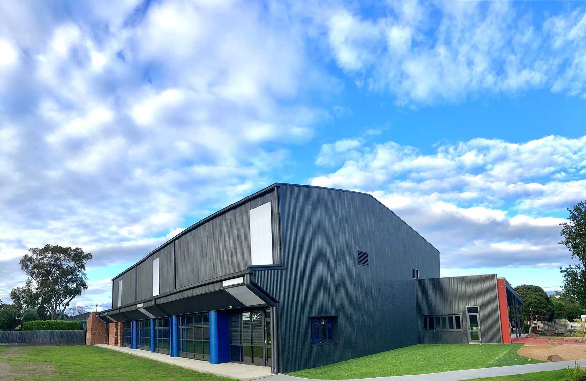 A large building with a blue sky and clouds in the background.