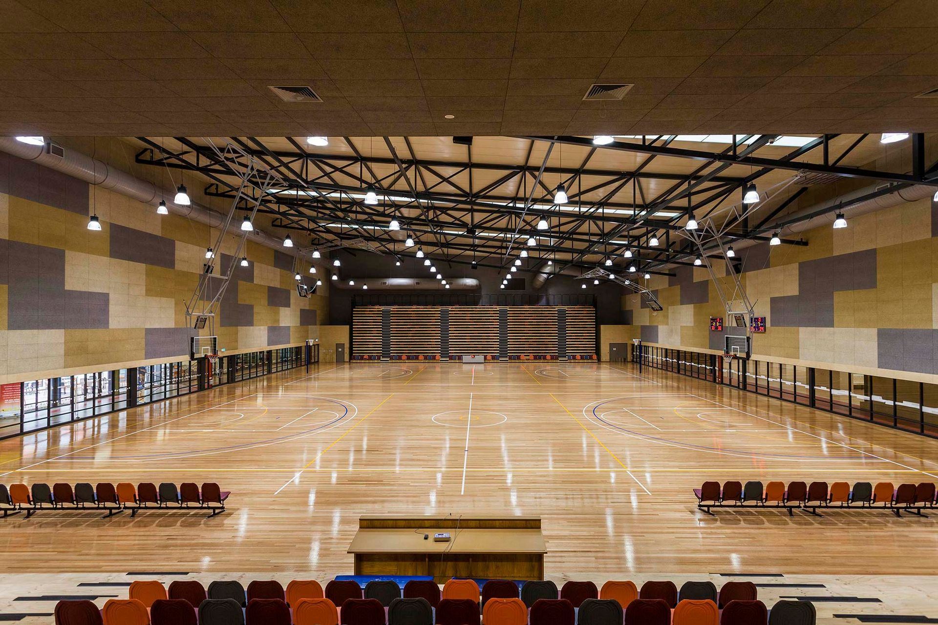 An empty auditorium with a wooden floor and a podium in the middle