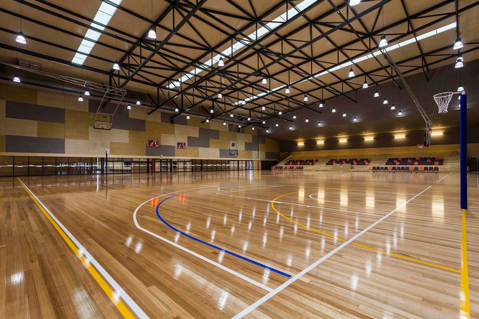 A large indoor basketball court with a wooden floor and a basketball hoop.