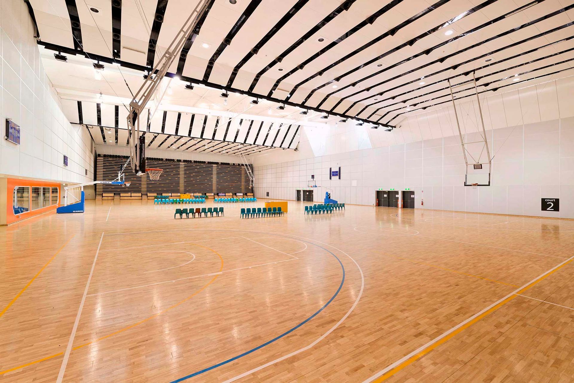 A large indoor basketball court with a wooden floor