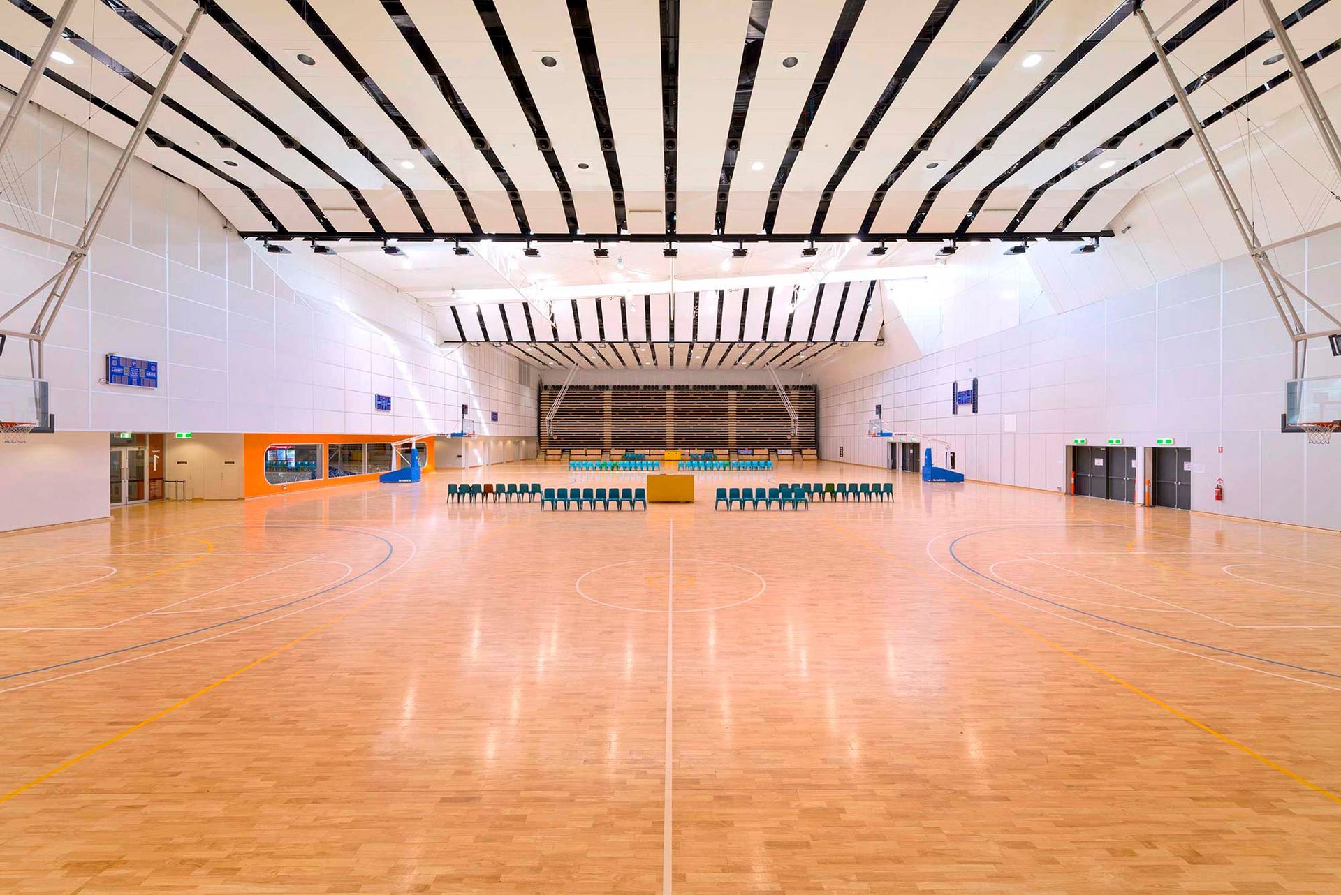 A large indoor basketball court with a wooden floor and a ceiling.