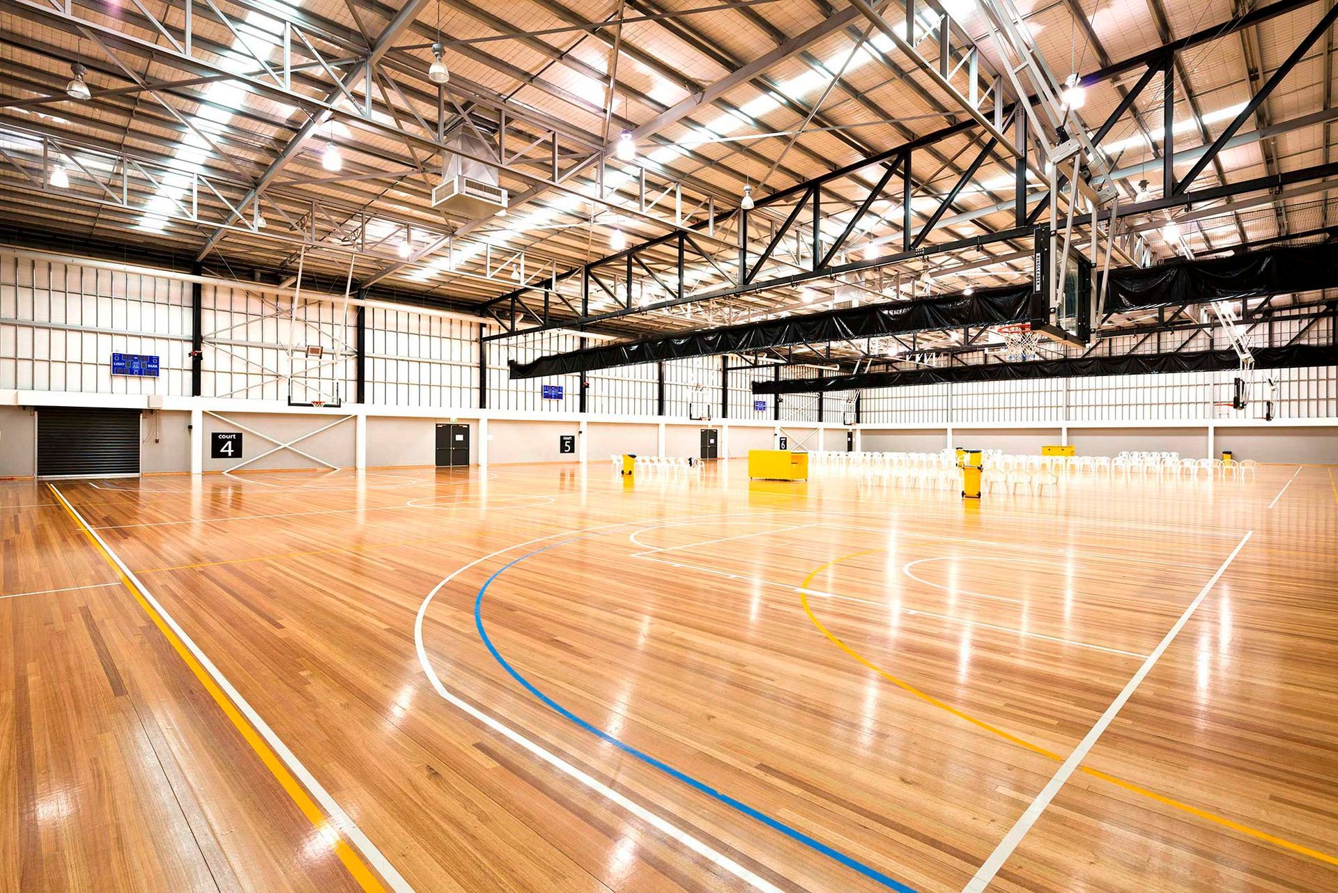 A large indoor basketball court with a wooden floor.