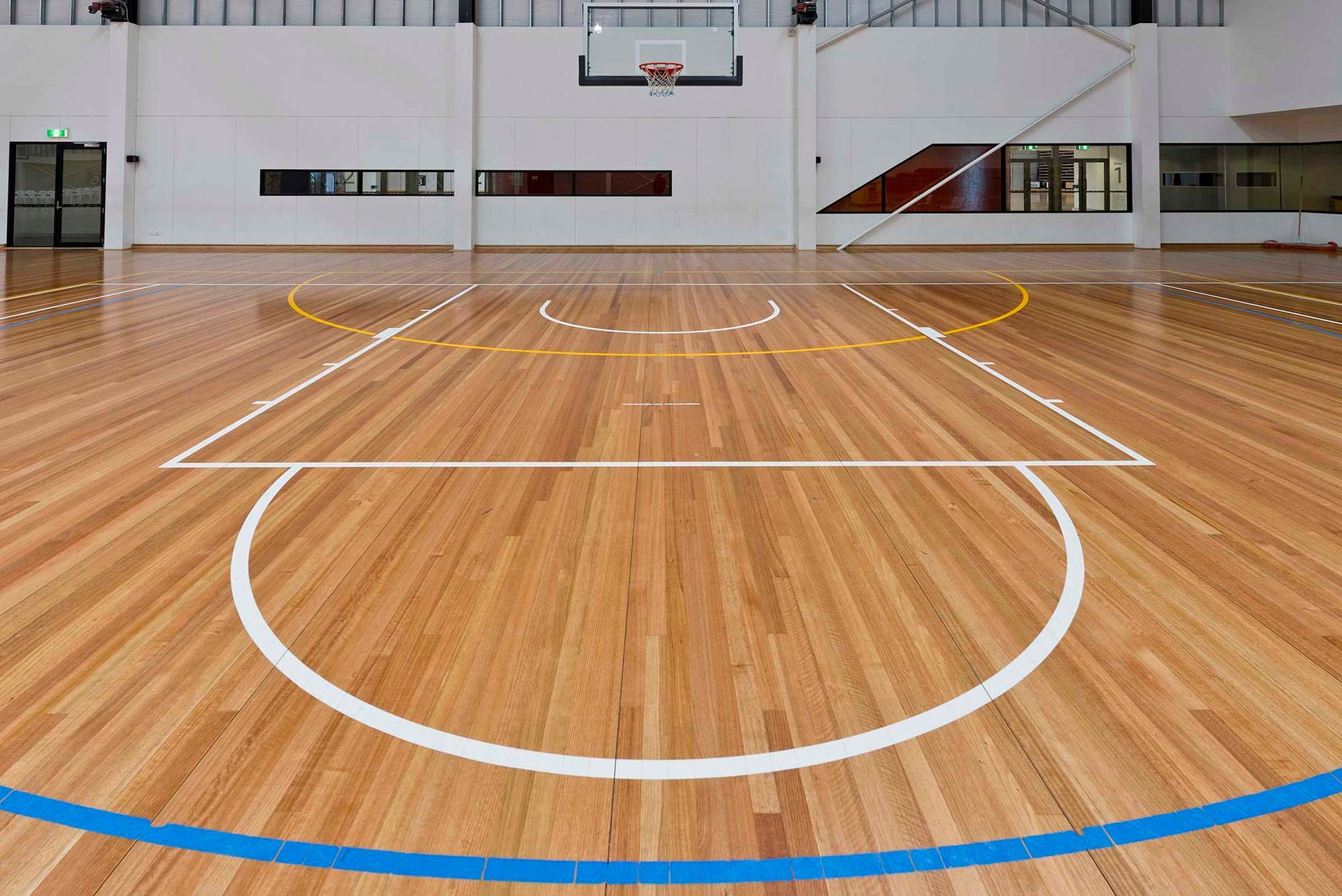A basketball court with a wooden floor and white lines