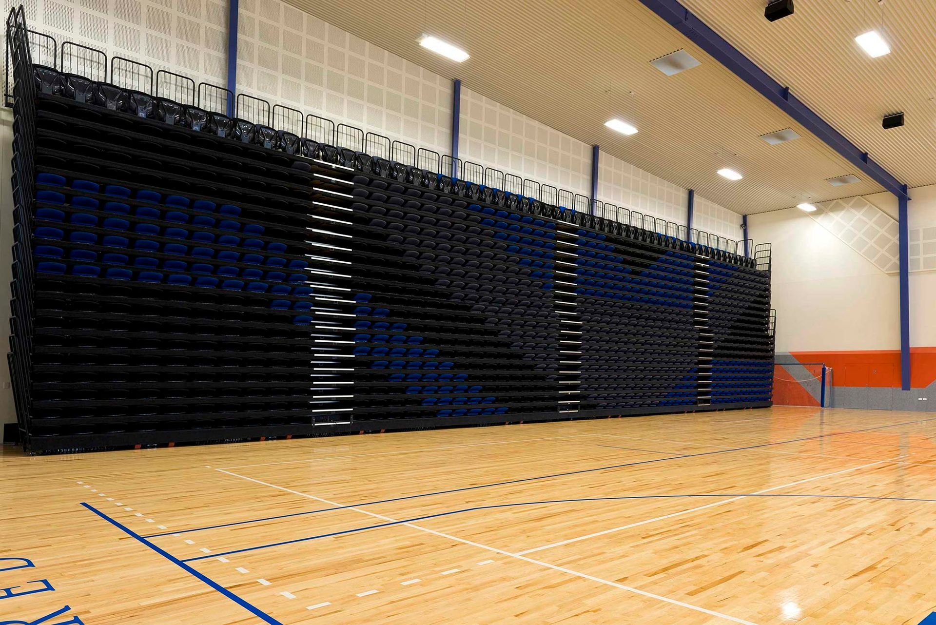 A large indoor basketball court with bleachers and a wooden floor