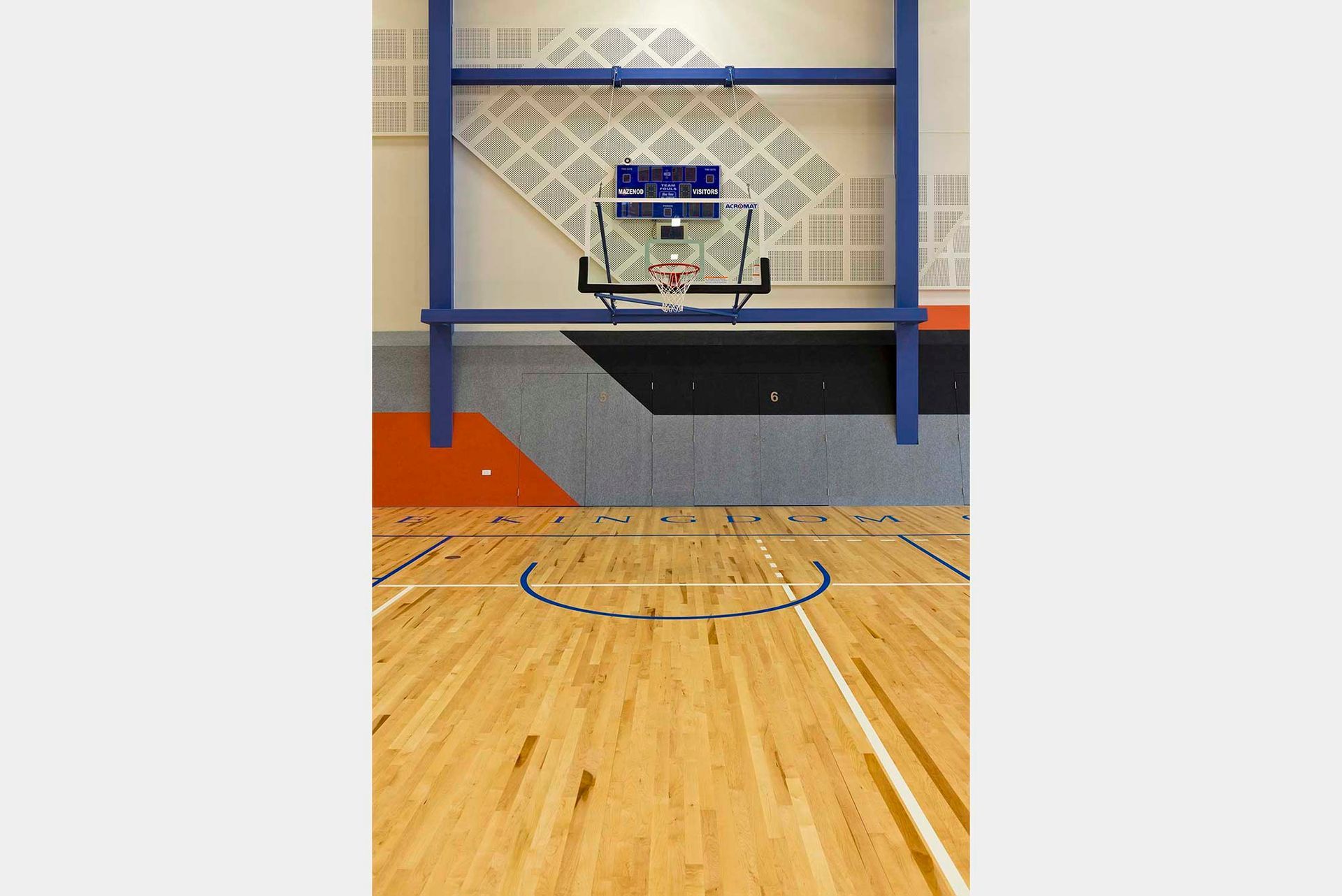 A basketball court with a wooden floor and a basketball hoop.