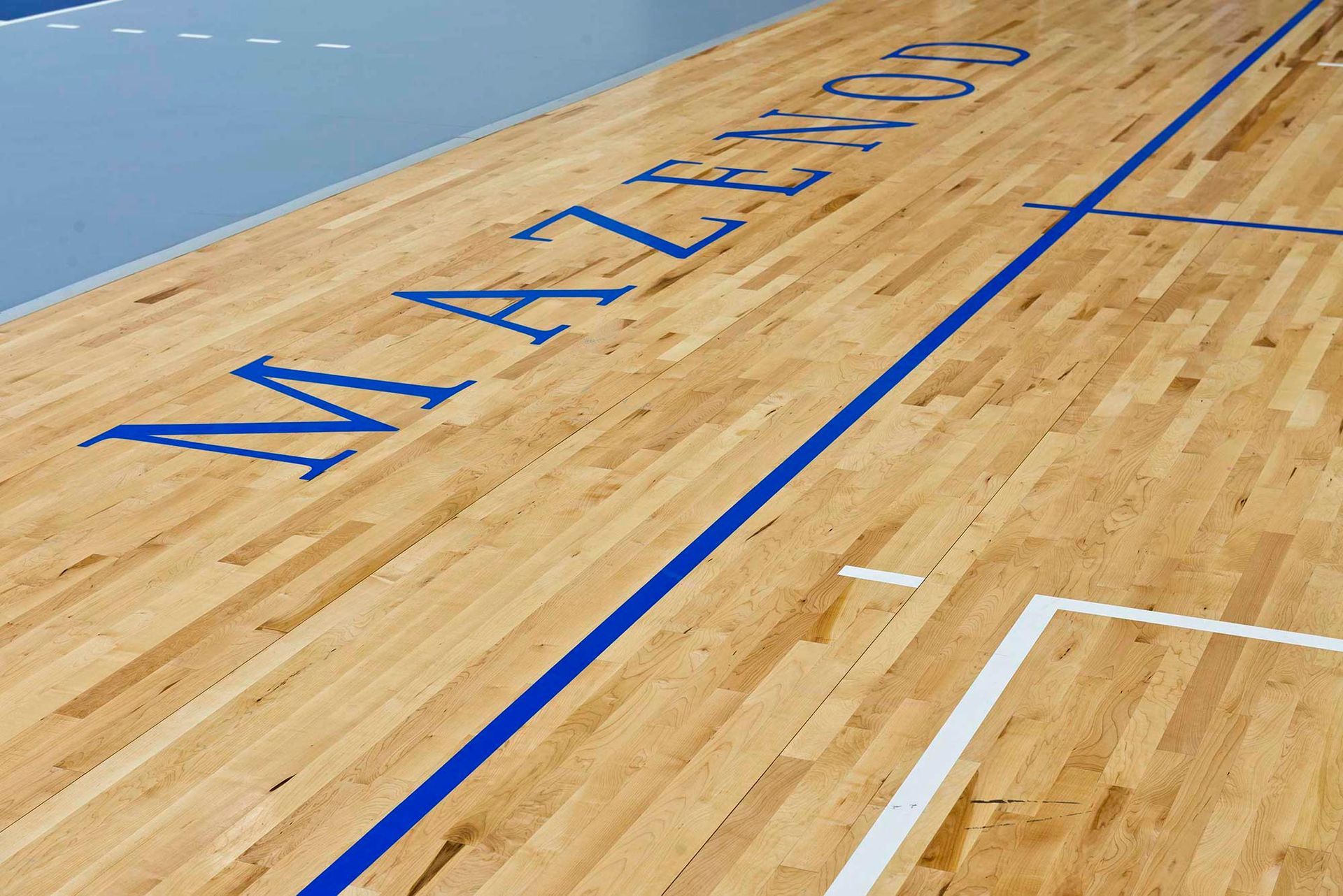 A wooden floor with the word mazenod written on it