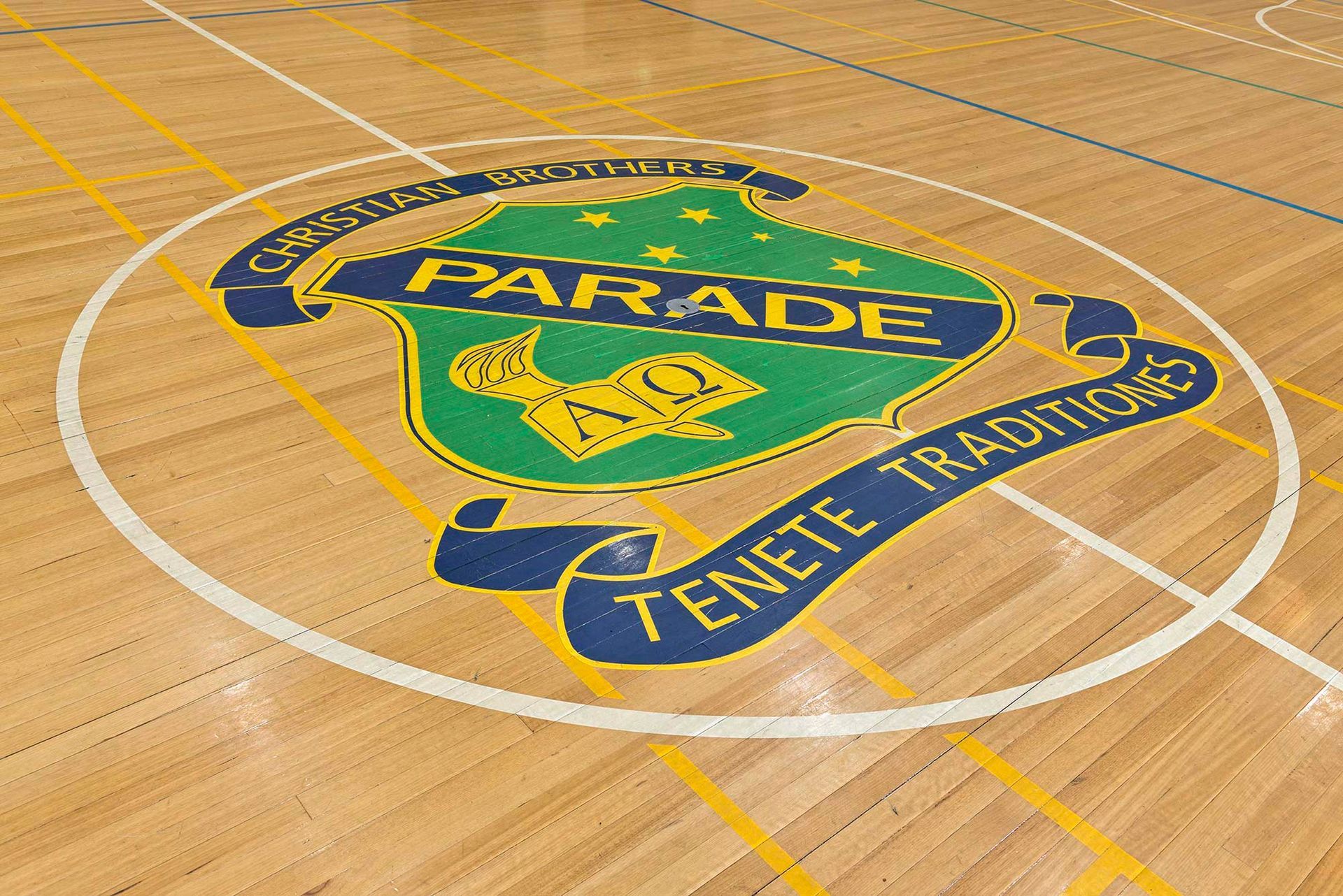 A parade logo is painted on the floor of a gym