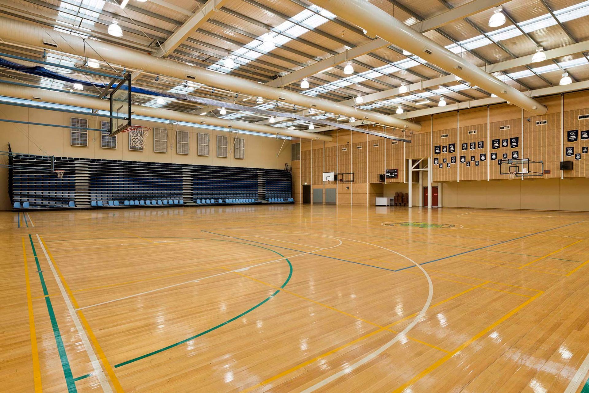 A large indoor basketball court with a wooden floor