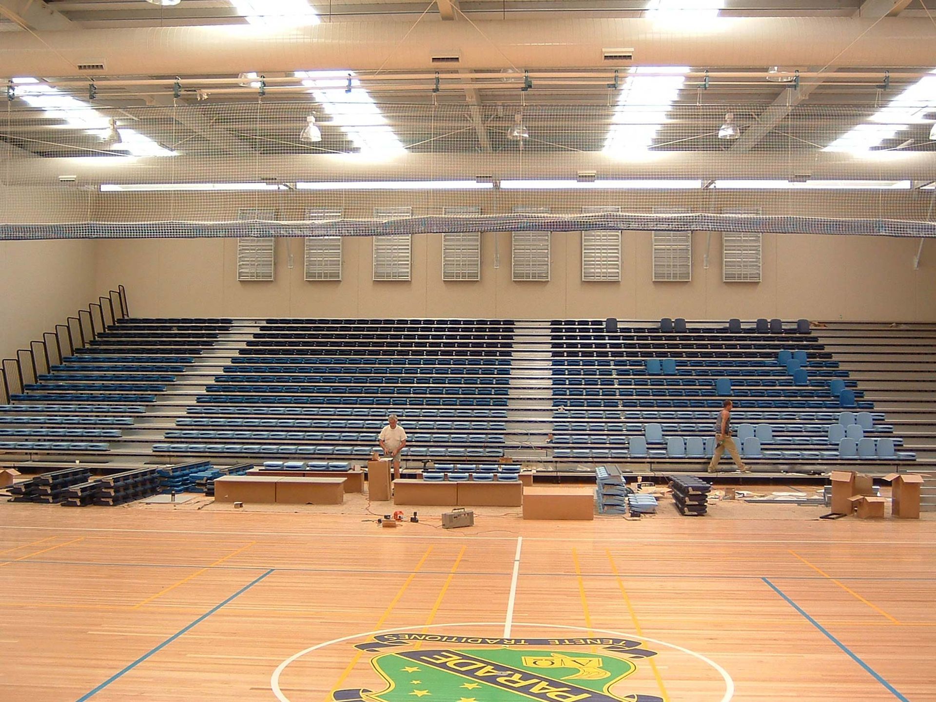A gym with bleachers and a basketball court with a logo that says ' columbia ' on it