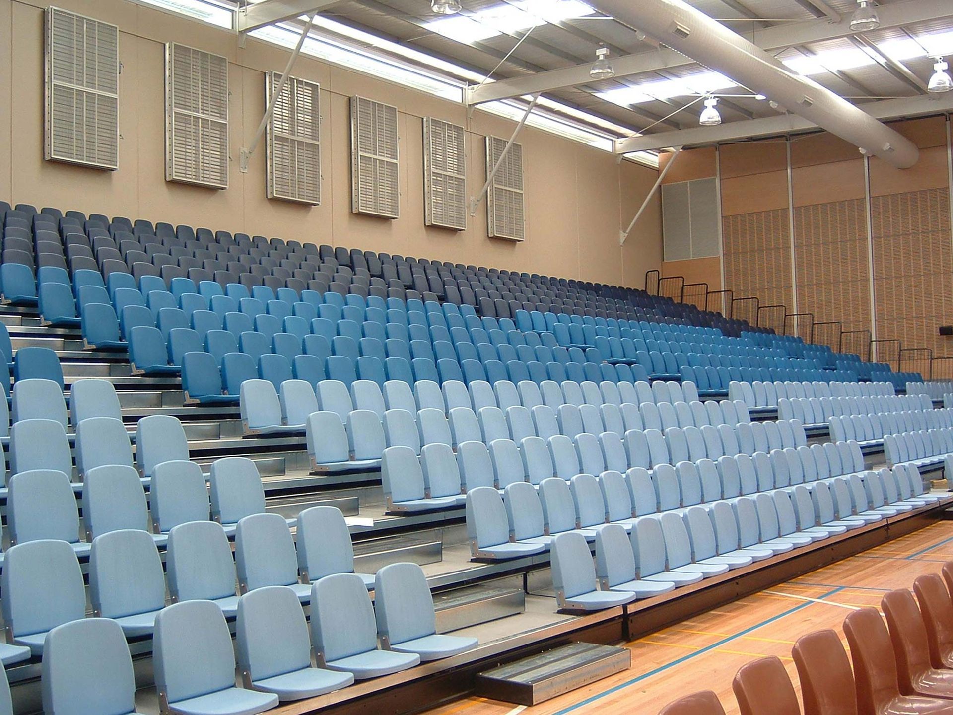 A large auditorium with rows of blue and brown seats