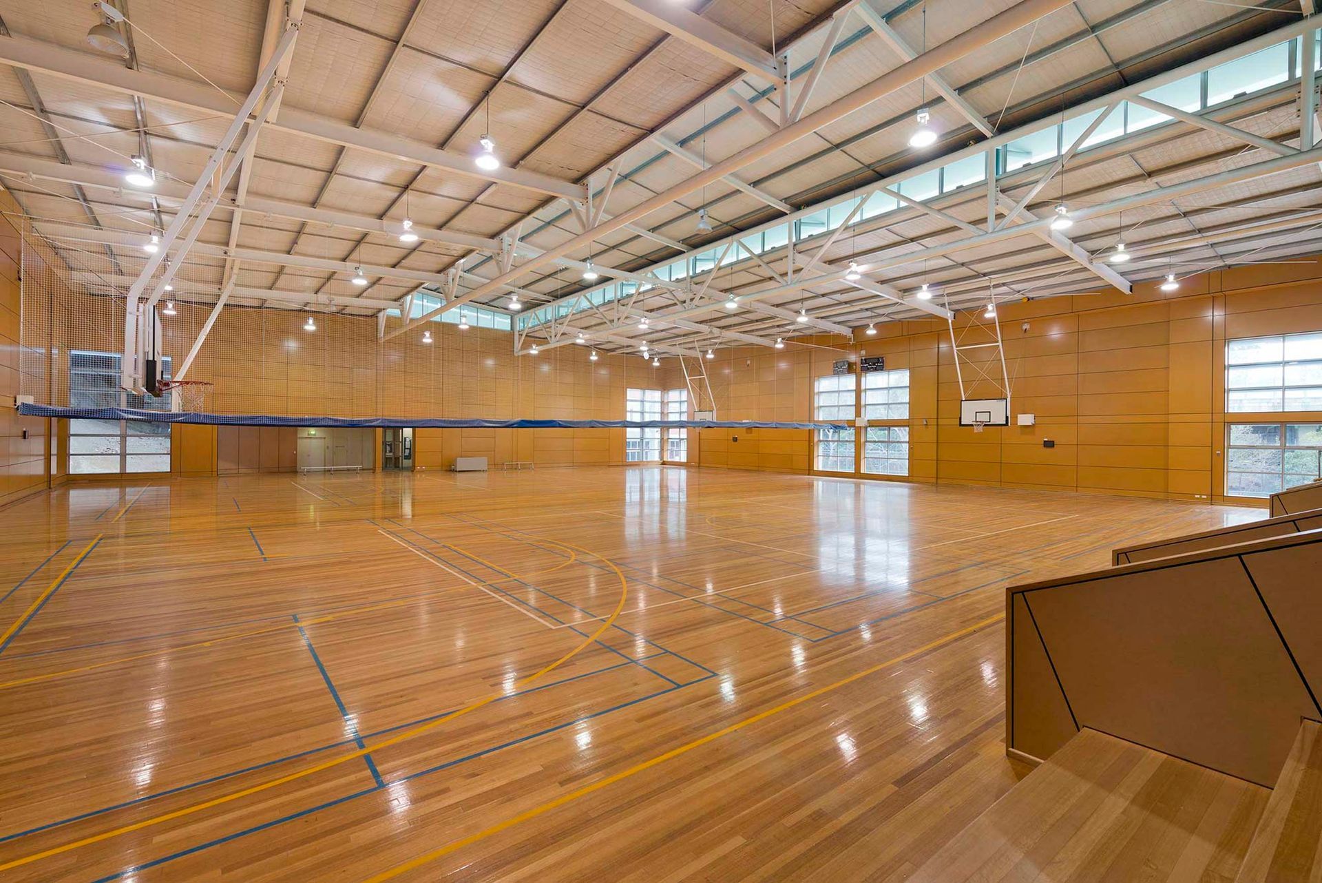 A large indoor basketball court with a wooden floor and a basketball hoop.