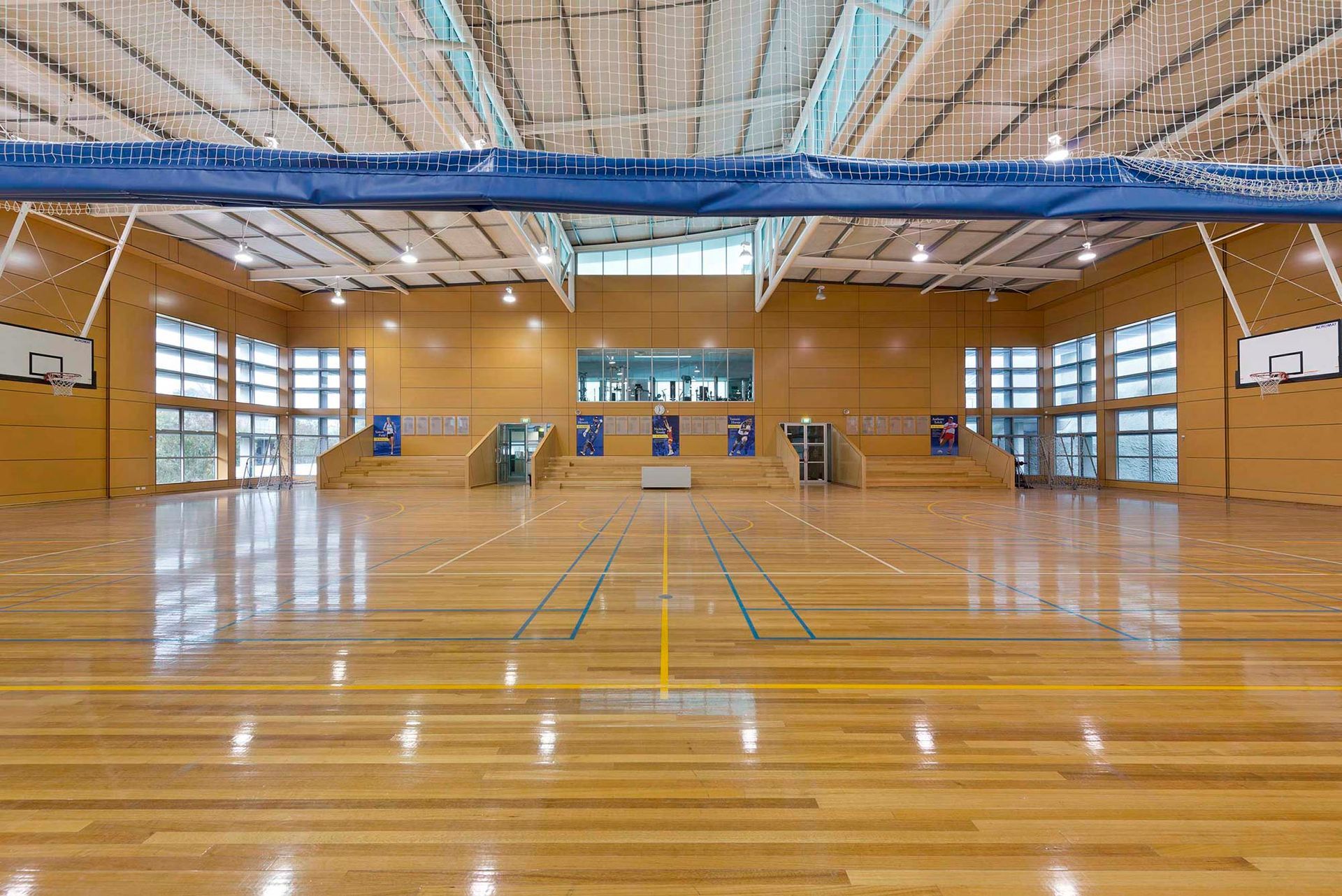 A large indoor basketball court with a wooden floor and a basketball hoop.
