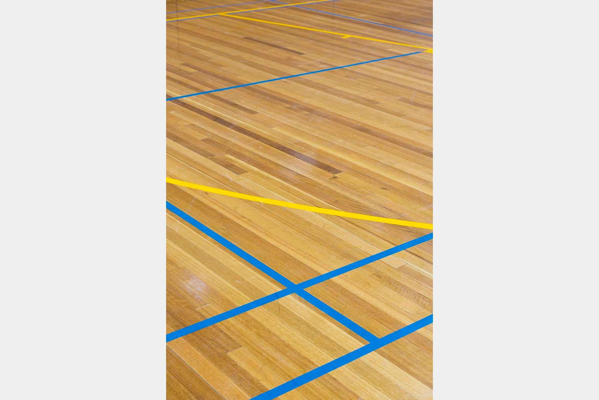 A wooden floor with blue and yellow lines on it.