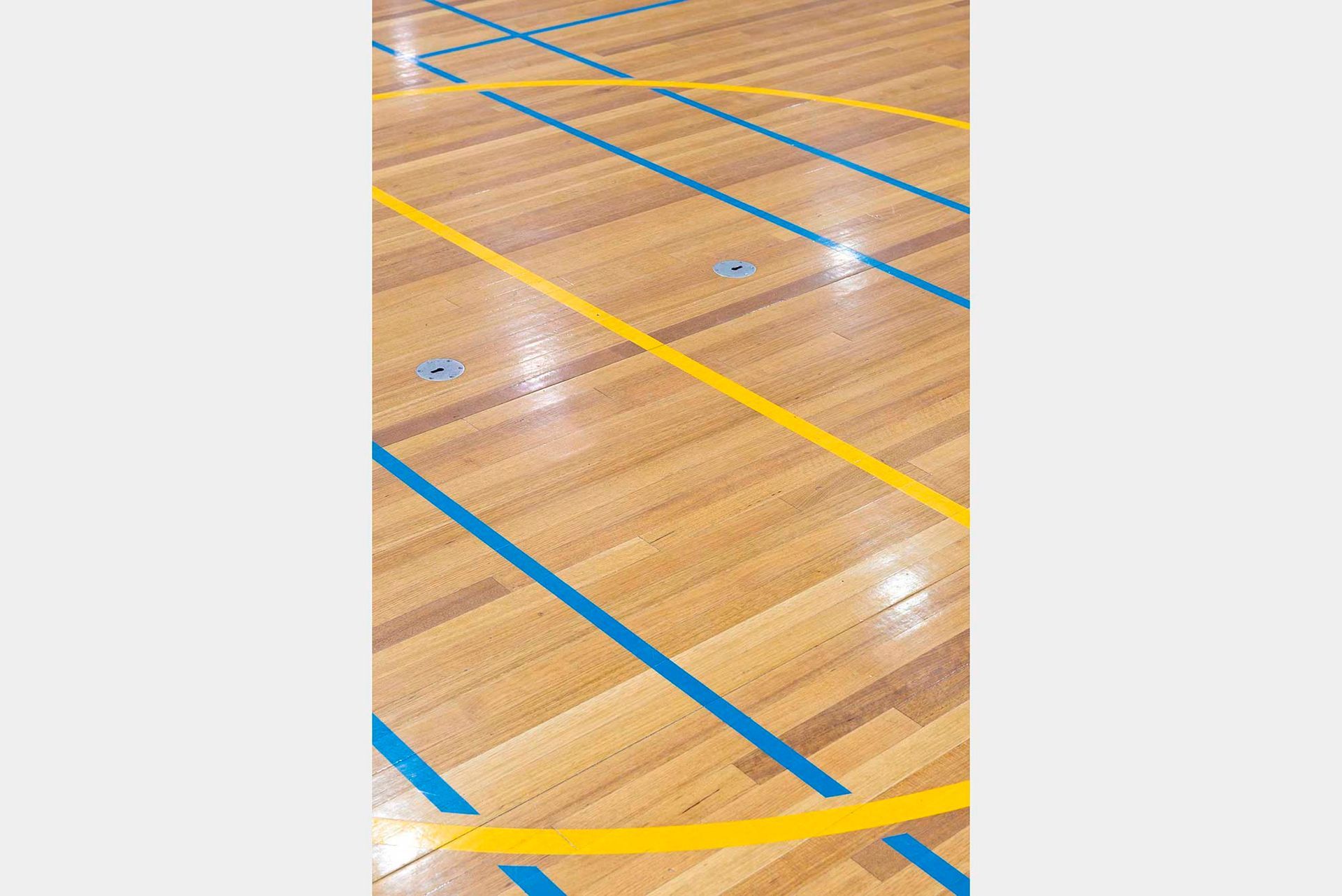 A wooden floor with yellow and blue lines on it.
