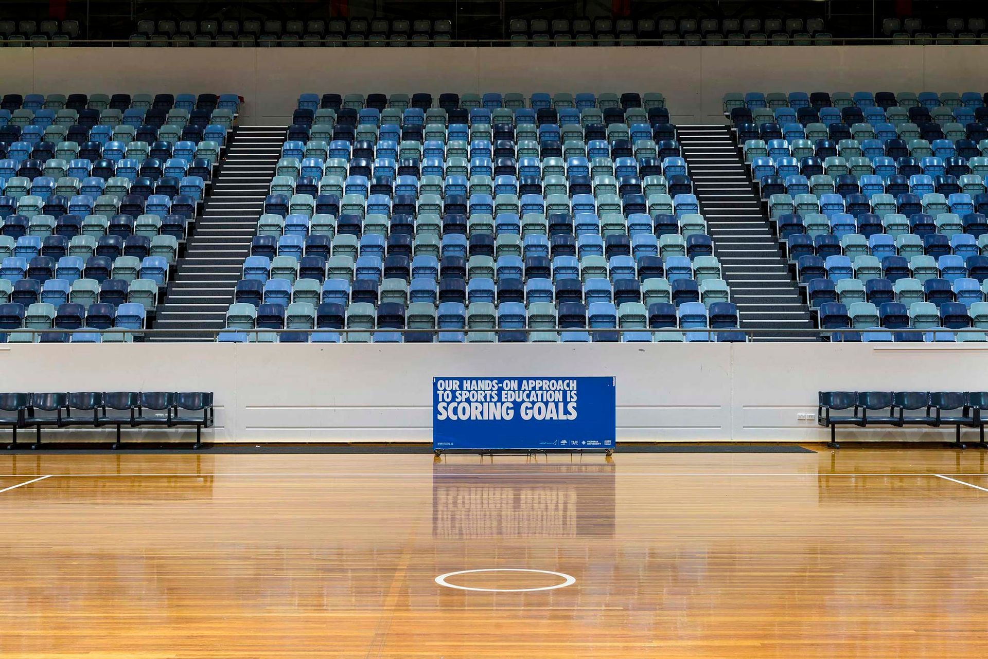 An empty basketball court with a sign that says