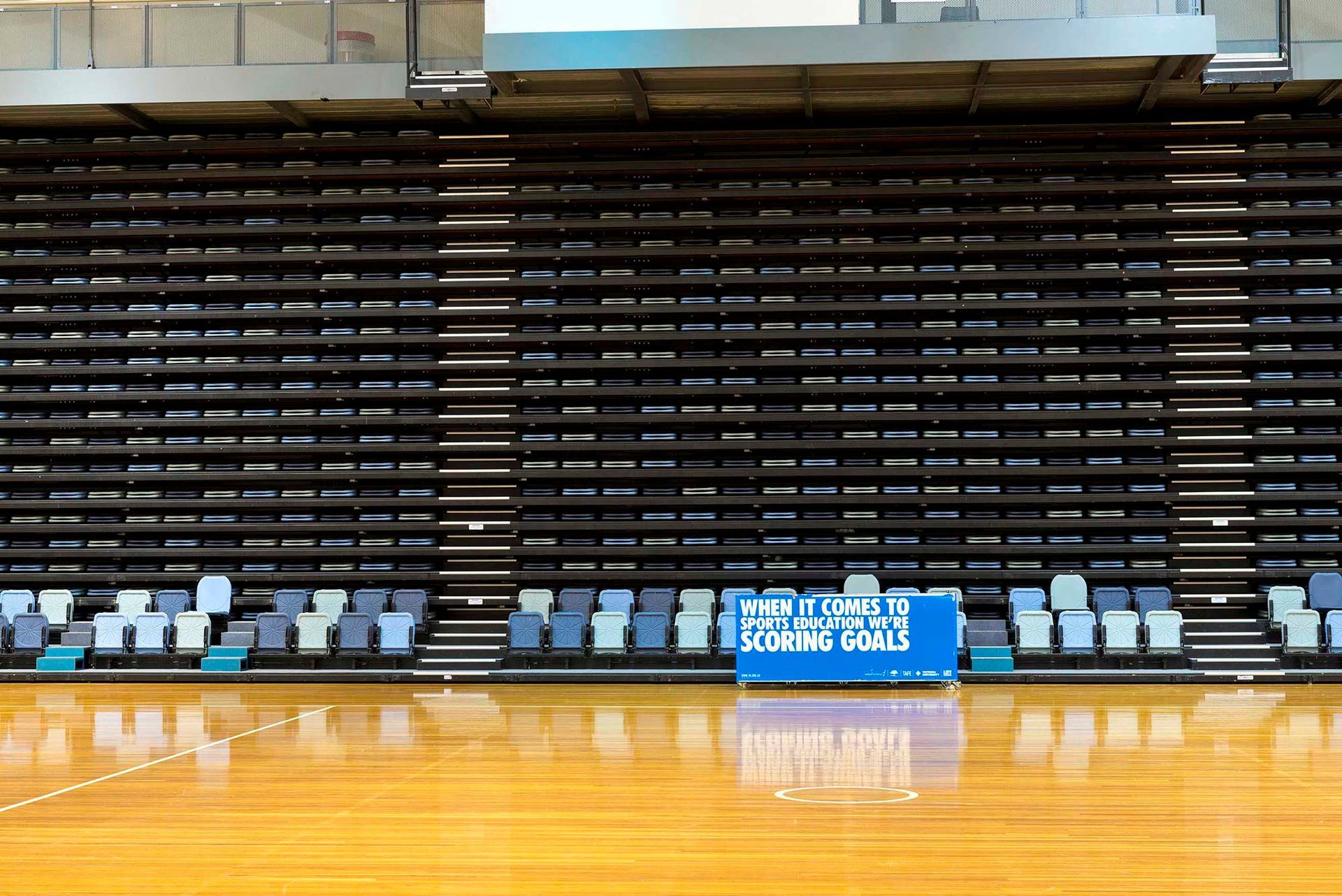 An empty basketball court with bleachers and a sign that says time out